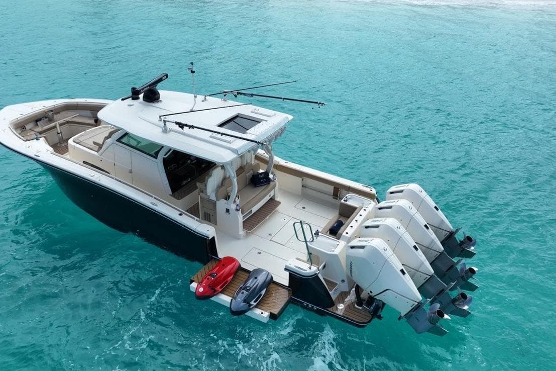 2024 Scout 400 LXF boat with four engines on turquoise water.