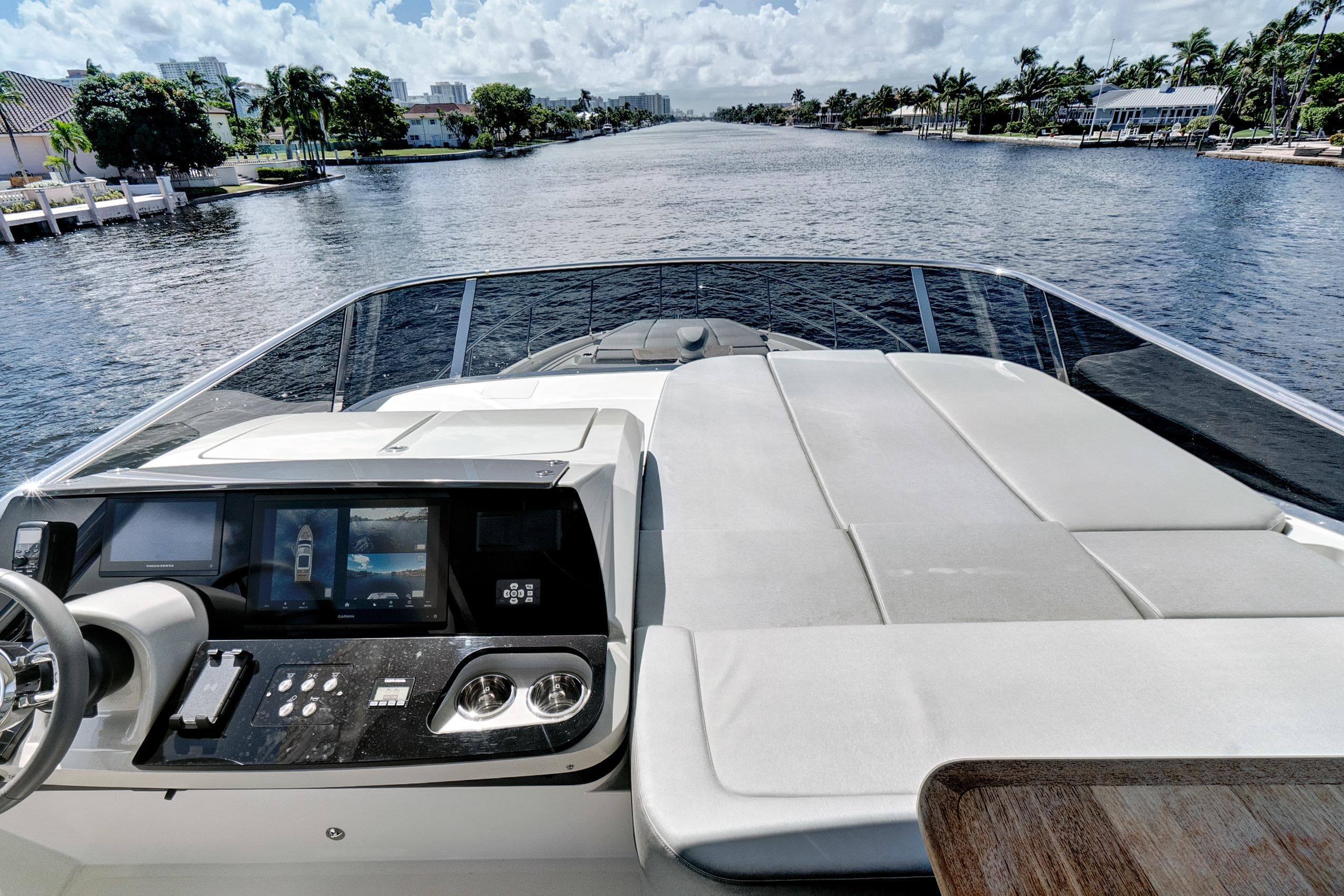 2025 Absolute 52 FLY yacht helm and sunbathing area on a scenic waterway.