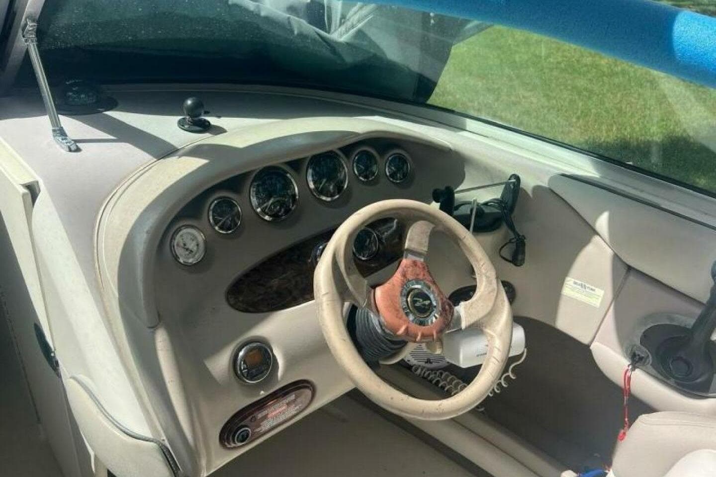 2003 Sea Ray 220 Bow Rider dashboard with steering wheel and gauges.