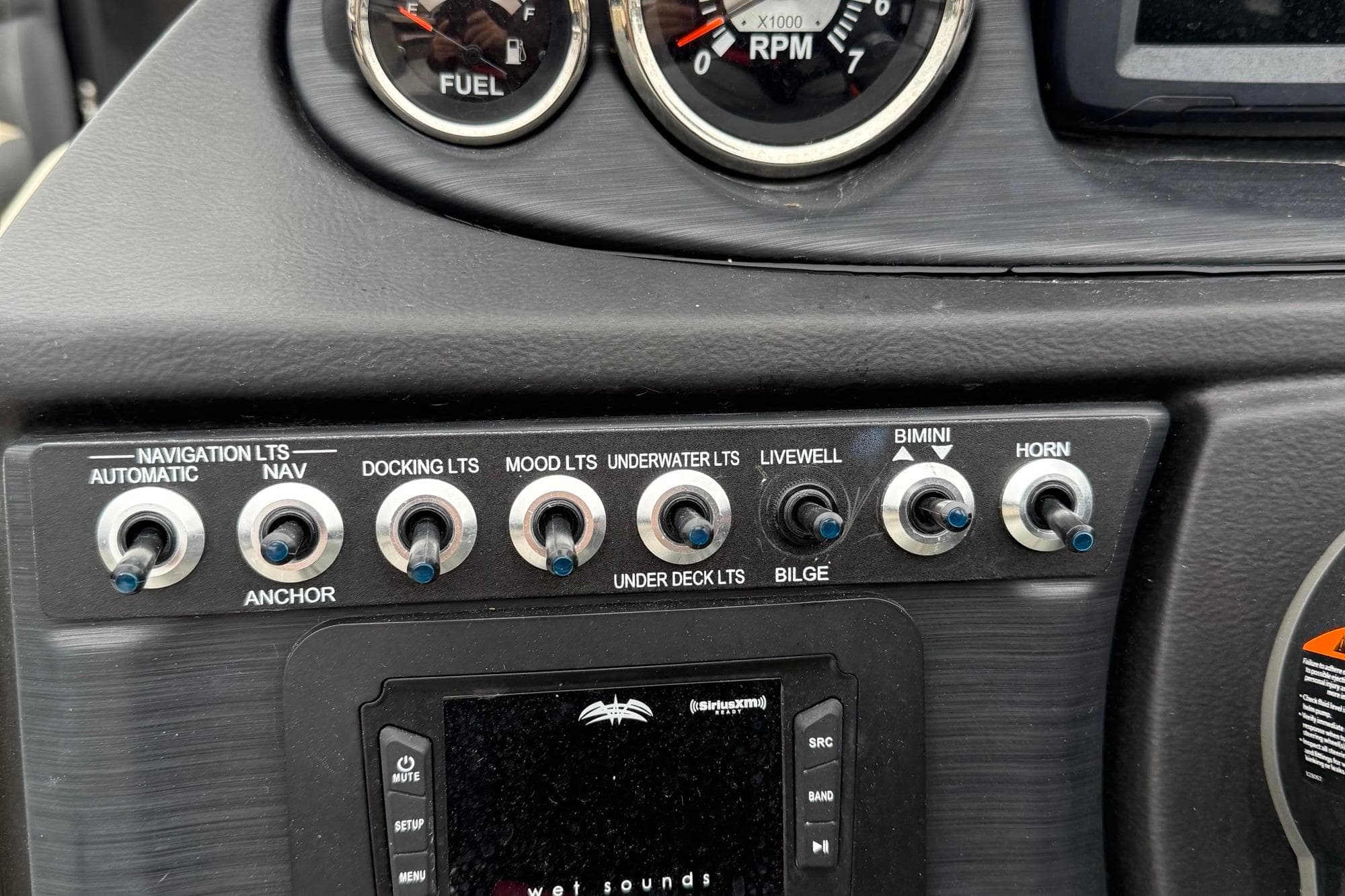 Control panel of 2024 Berkshire 22RFX CTS boat with various switches and gauges.