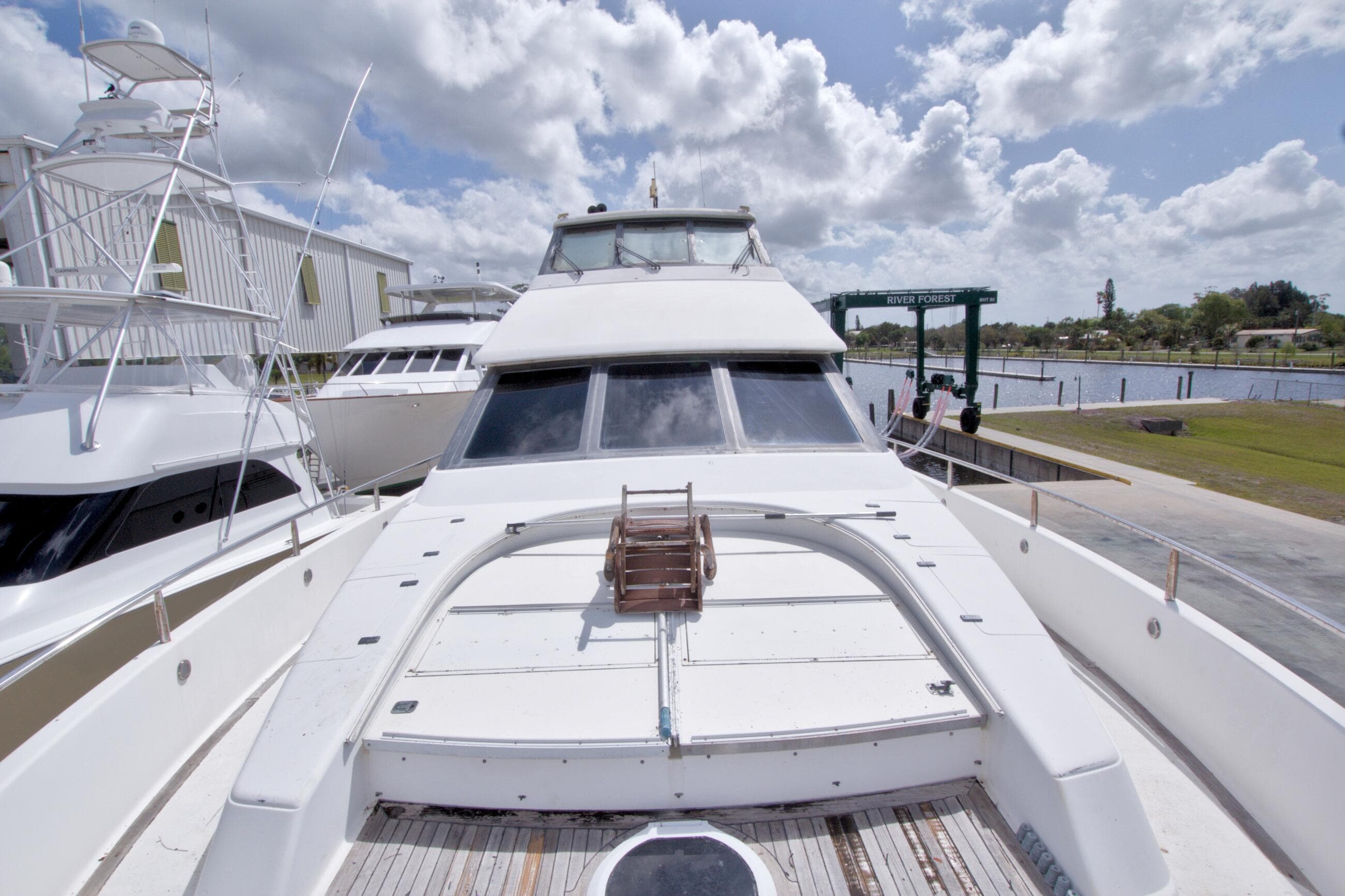 1998 Lazzara 76 Skylounge Grand Salon yacht docked under cloudy skies.