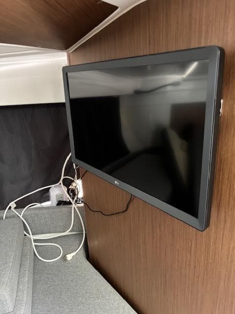 Flat-screen TV mounted in 2019 Beneteau Antares 27 cabin interior.