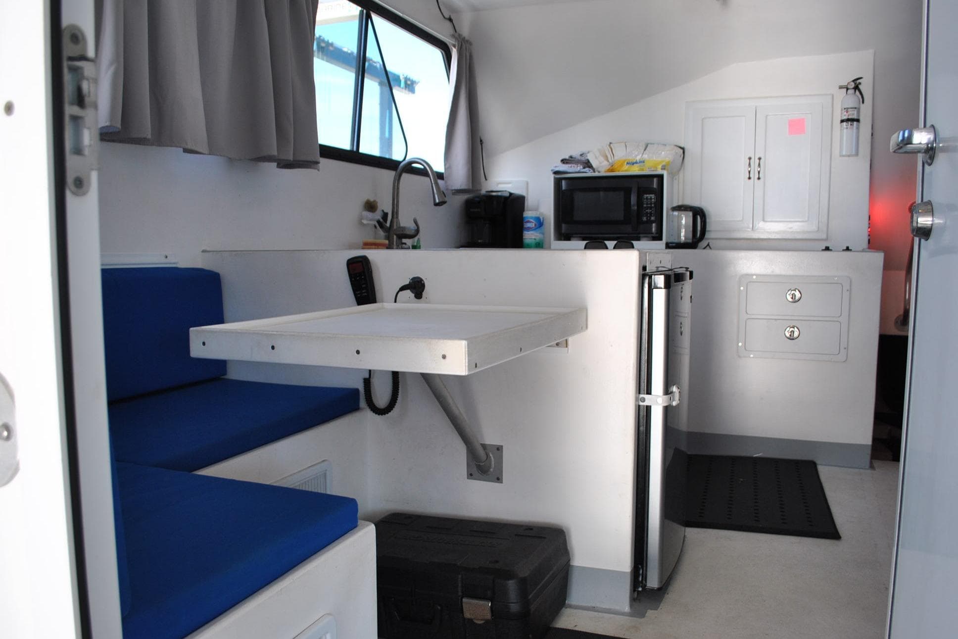 Interior of a 2019 Newton 53 dive boat with kitchenette and seating area.