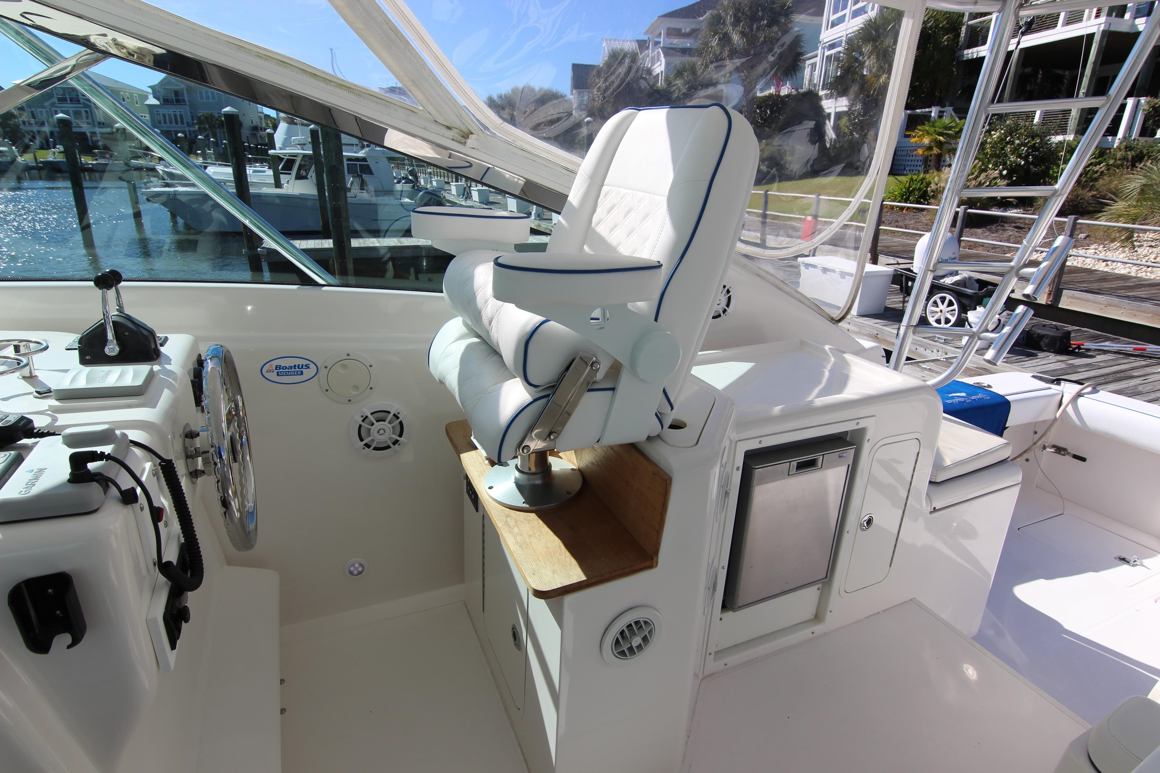 2008 Bertram 360 yacht cockpit with helm seat and control panel, docked at marina.