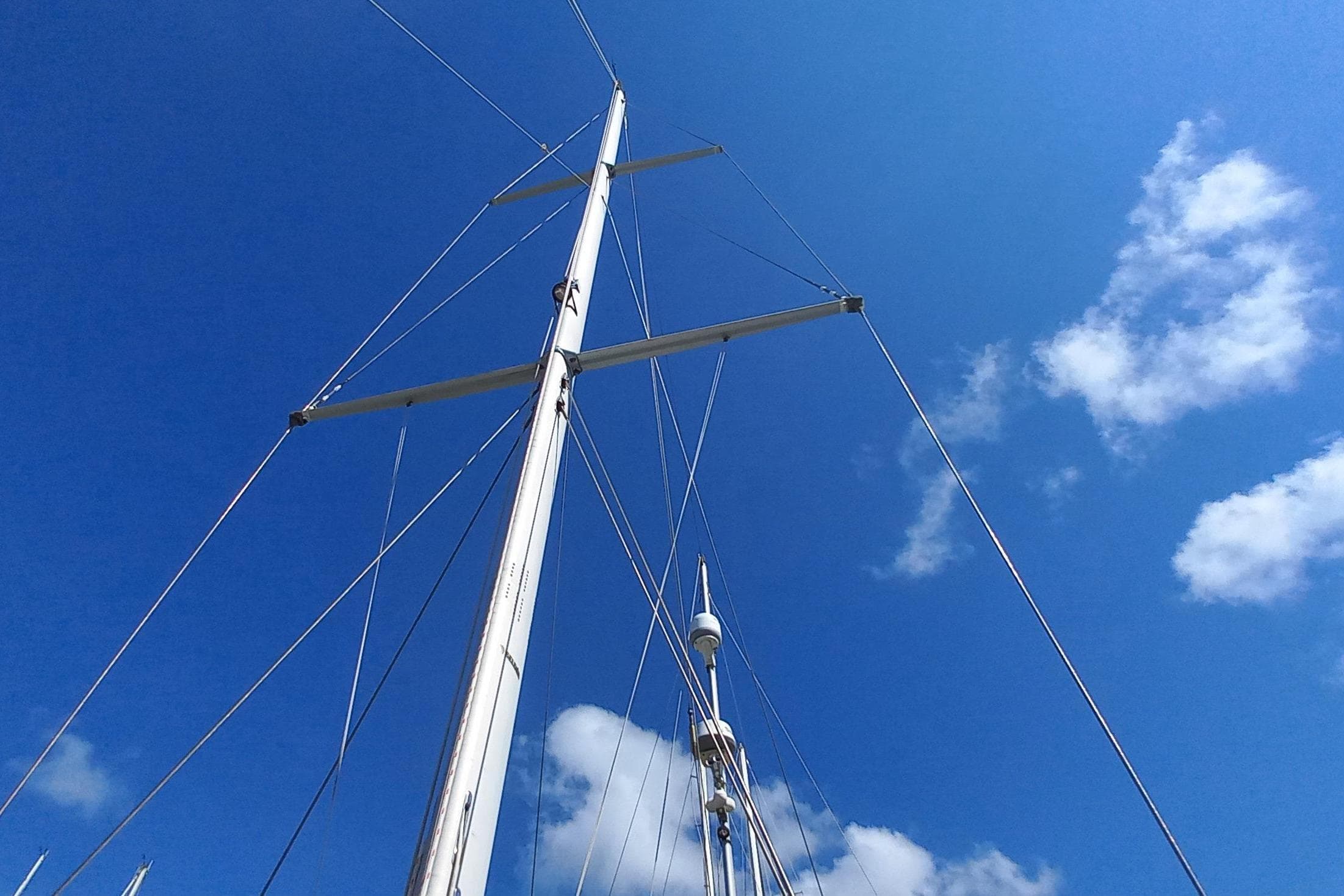 Tall sailboat mast against a clear blue sky, Hinckley 49, 1974 model.