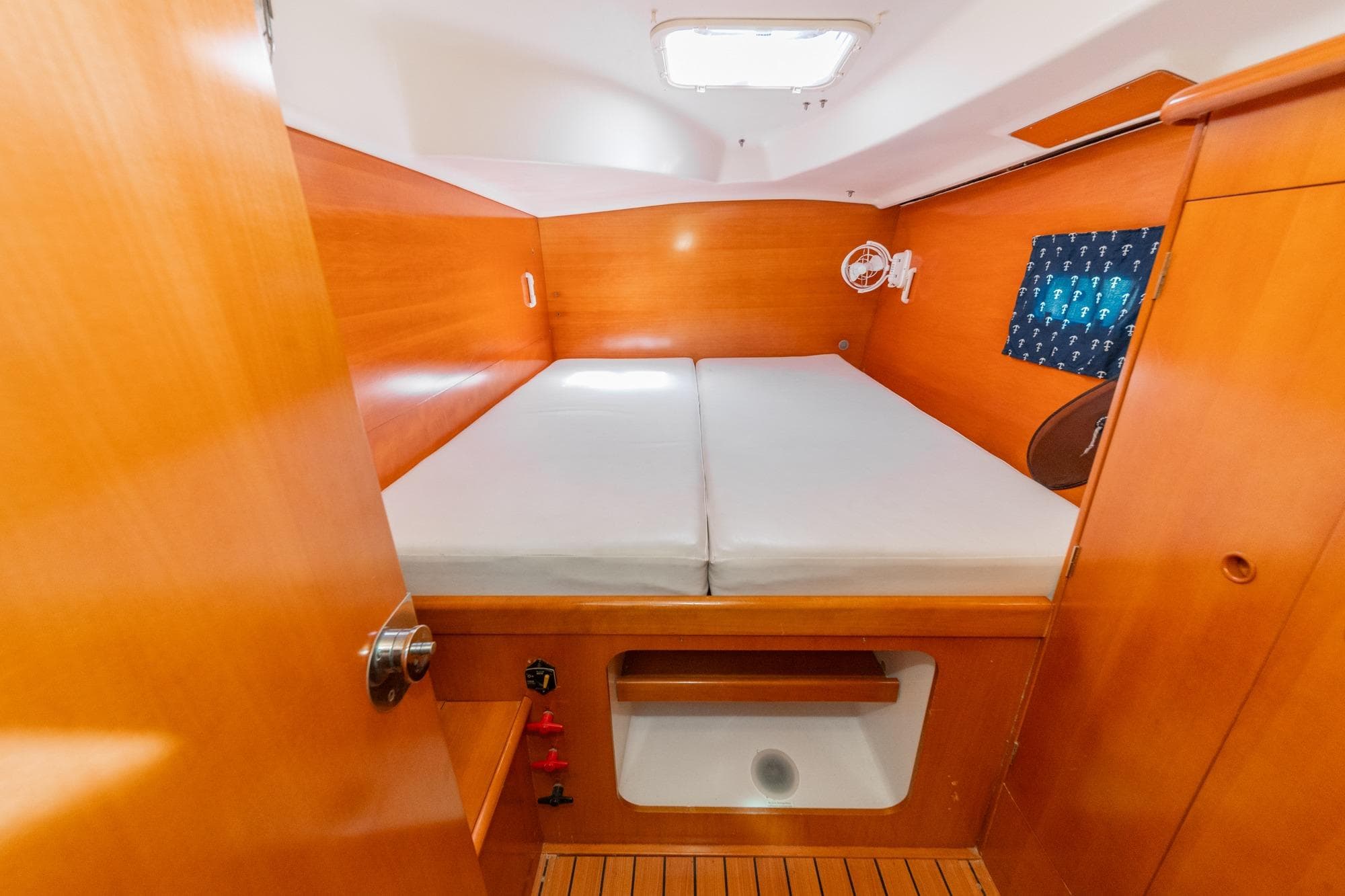 Cozy cabin interior of 2004 Lagoon 380 catamaran with wooden finish and double bed.