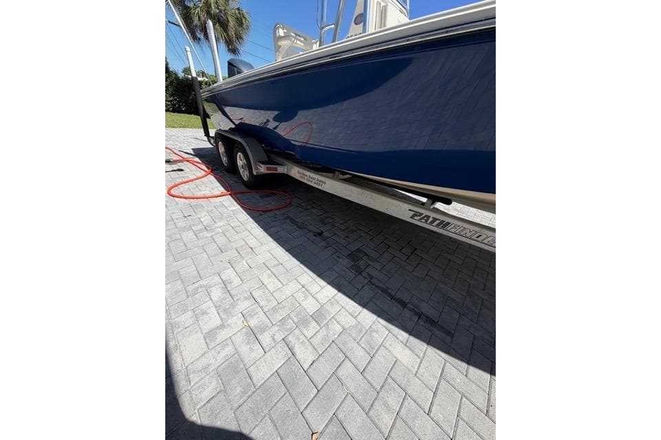 2018 Pathfinder 2500 Hybrid boat on trailer, parked on paved driveway.