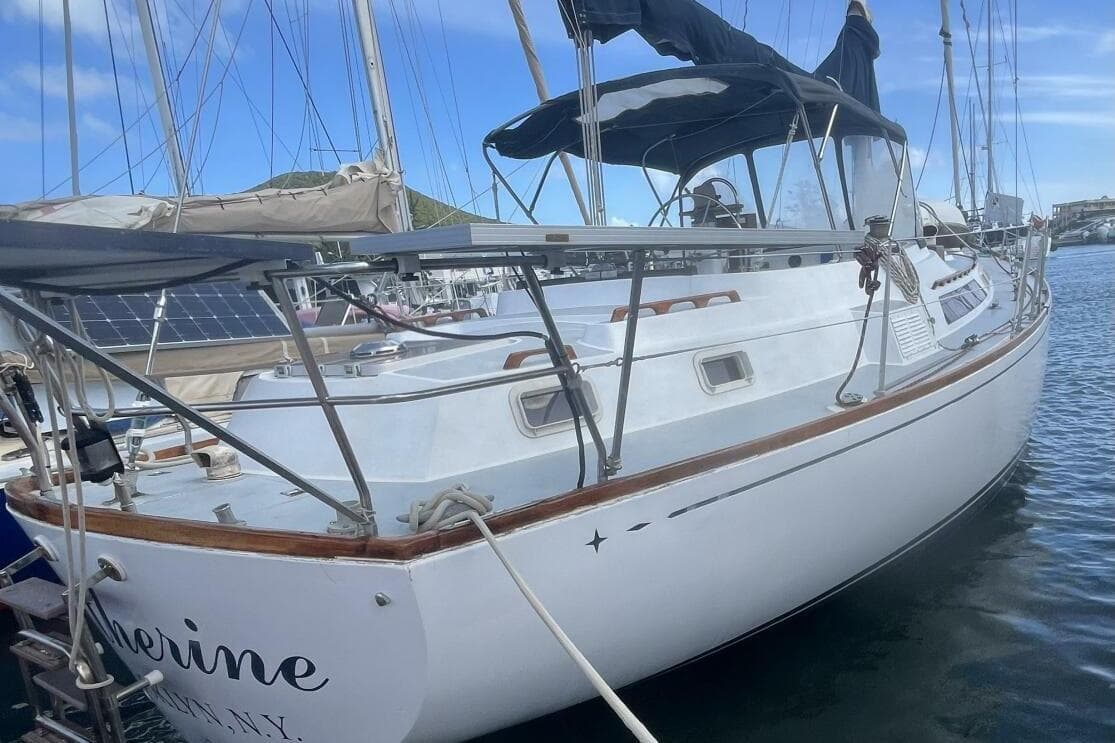 1982 C&C Landfall sailboat docked in marina, featuring sleek white hull and rigging.