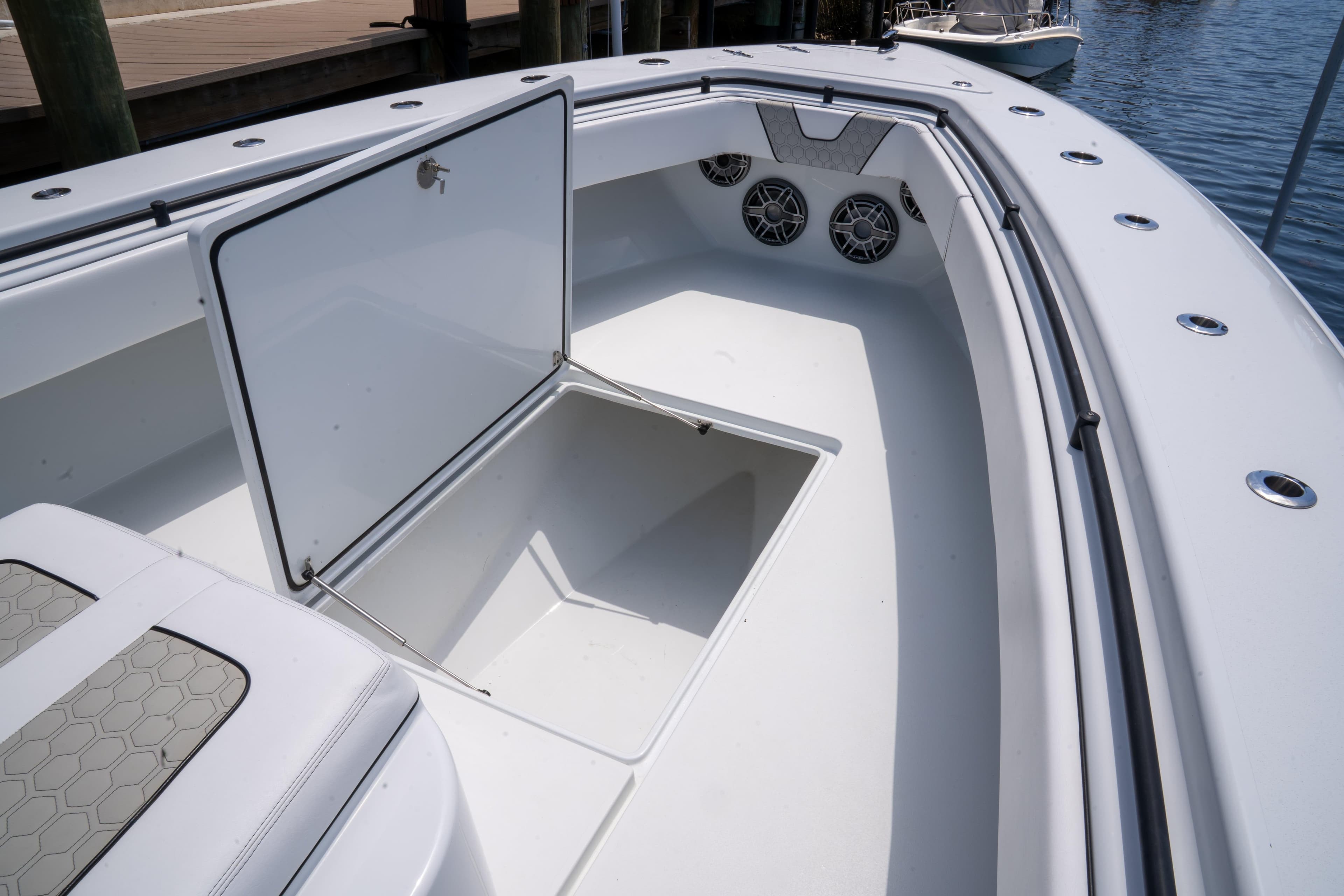 2023 Contender 44 CB boat with open storage compartment and speakers on deck.