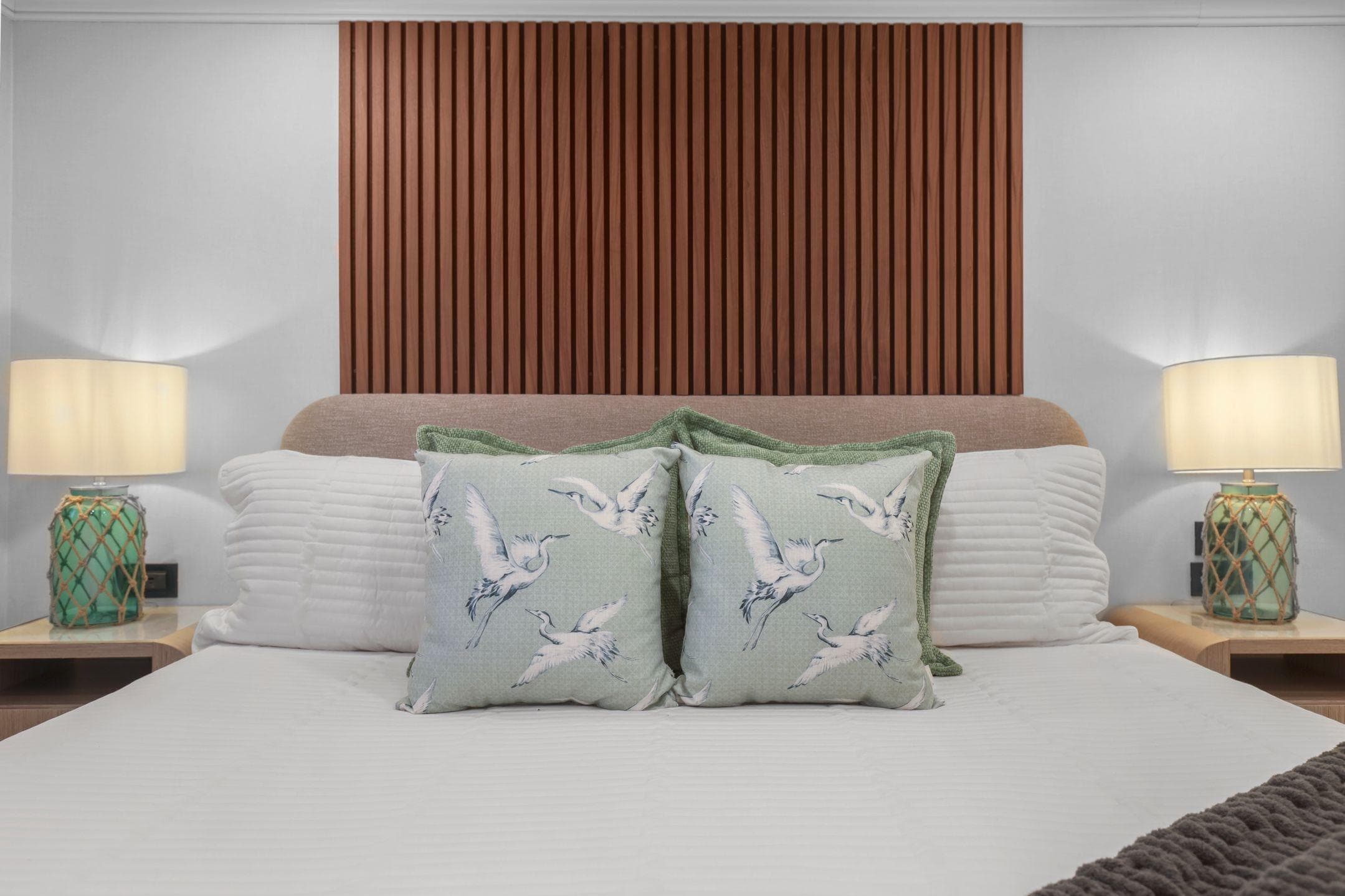 Luxurious bedroom on Mengi Yay 115 MY yacht, featuring elegant decor and bird-themed cushions.