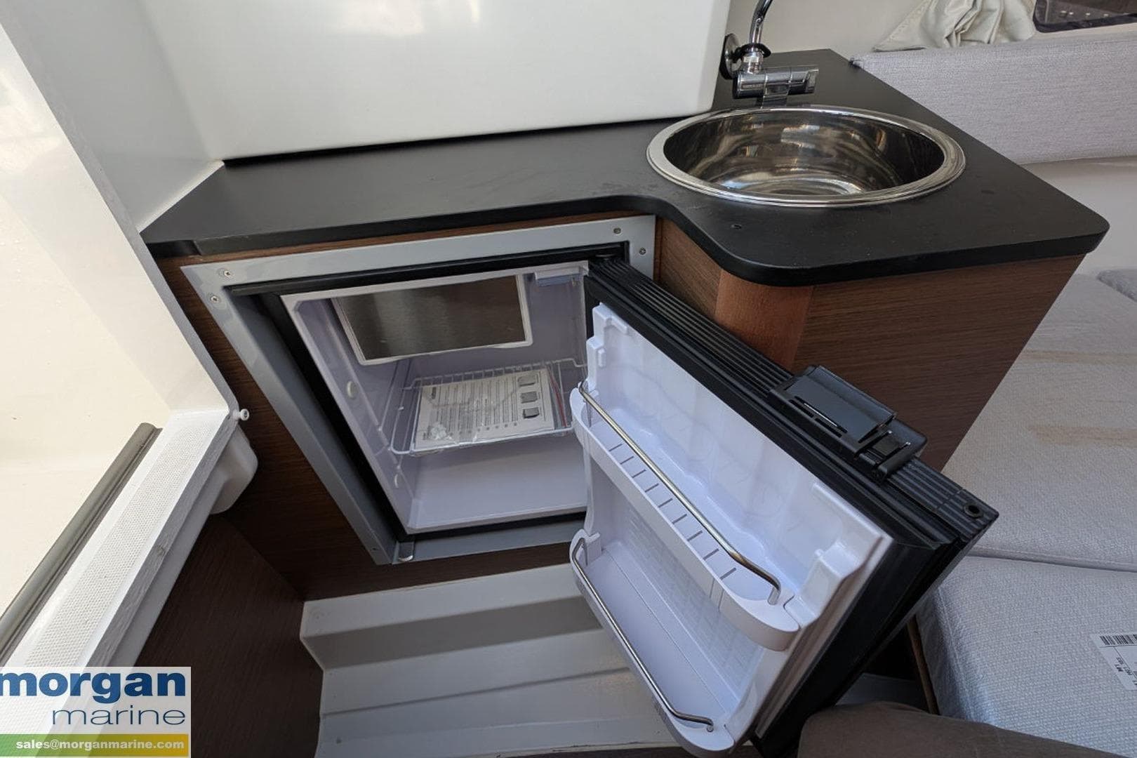 2024 Jeanneau Cap Camarat 7.5 WA interior with open fridge and sink.
