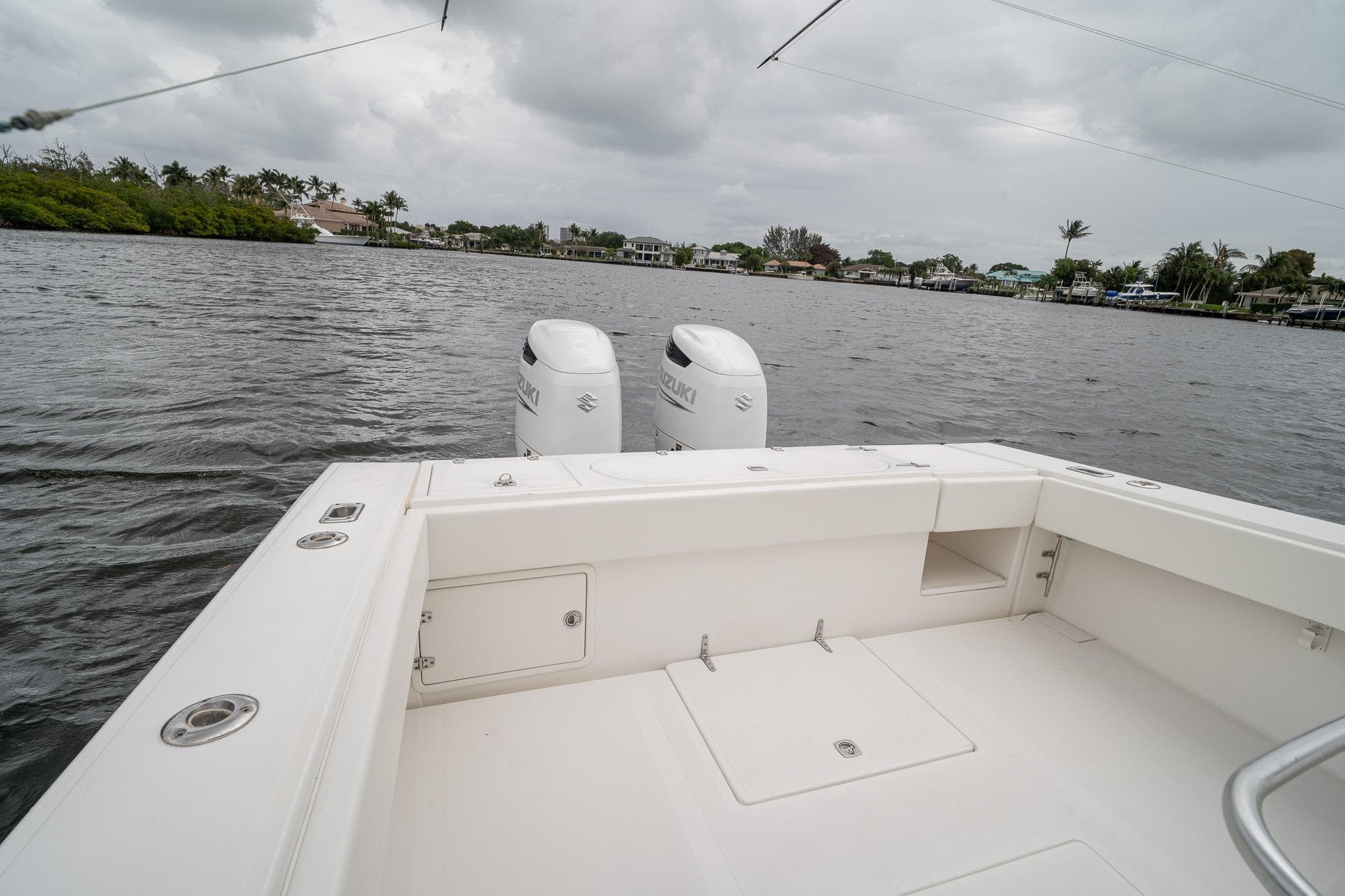 2006 Venture Center Console boat with dual Suzuki engines on a calm waterway.