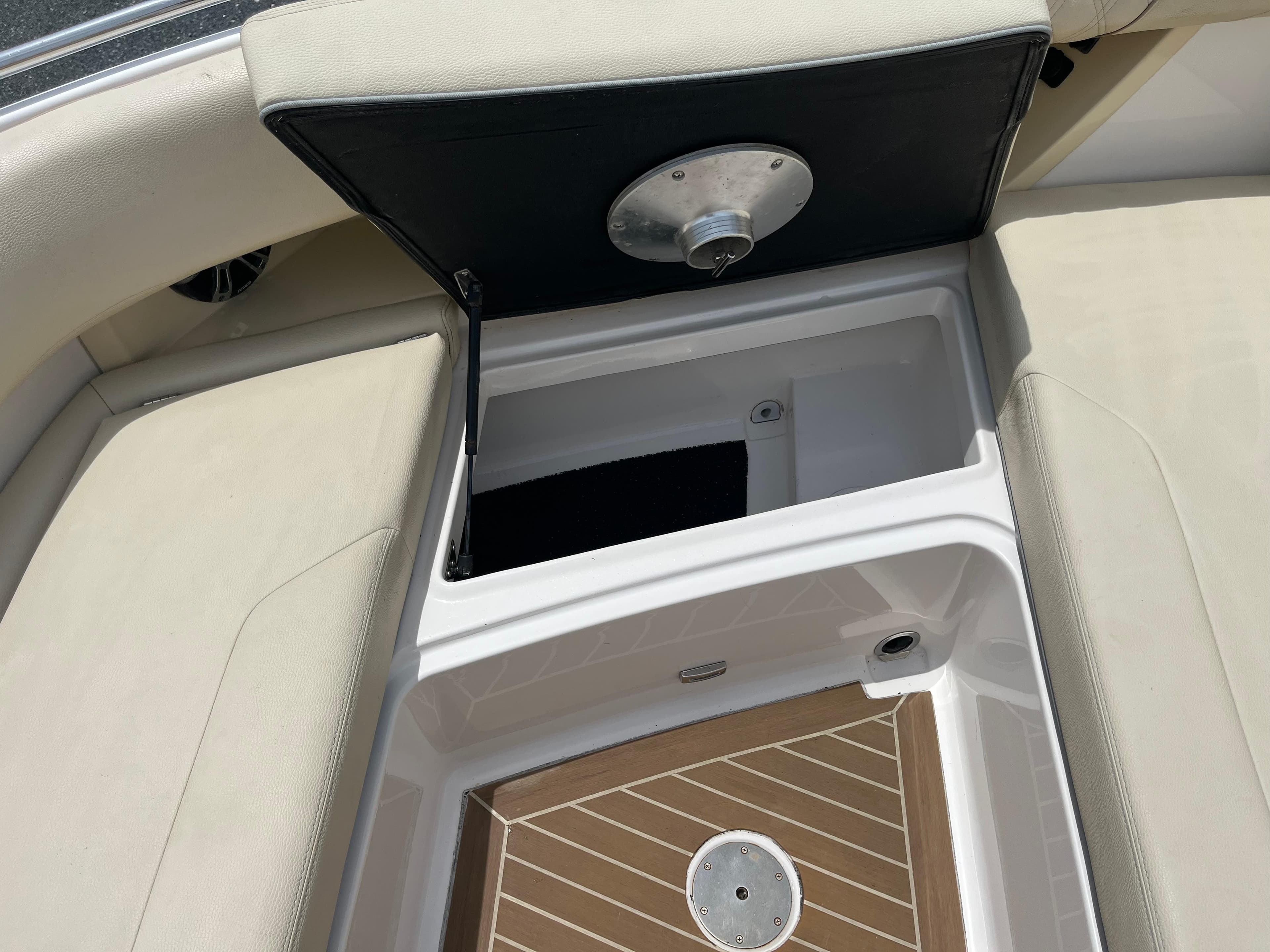 Open storage compartment on a 2019 Regal 33 SAV boat with cushioned seating.