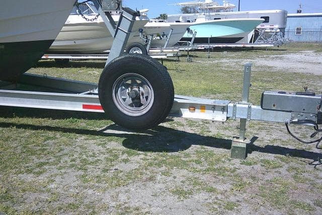 Trailer for 2004 Grady White 27 Islander boat on grassy lot.