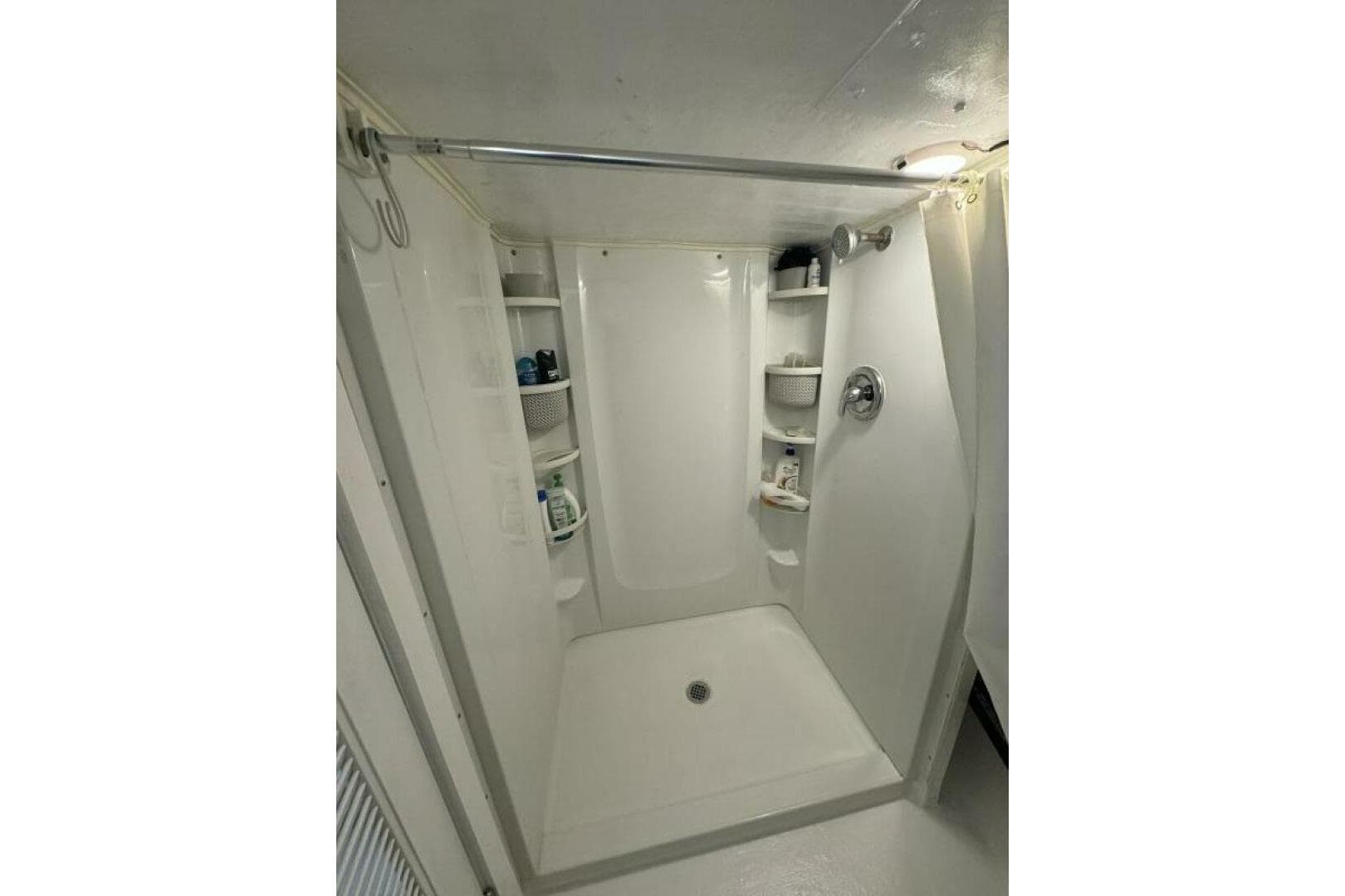 Compact shower area with shelves in a 1987 Monroe Custom 52.