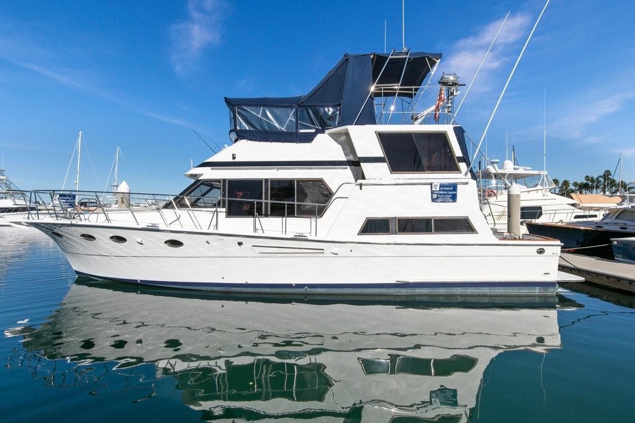 1989 Lien Hwa Vitesse Yachtfisher docked in a marina under clear blue skies.