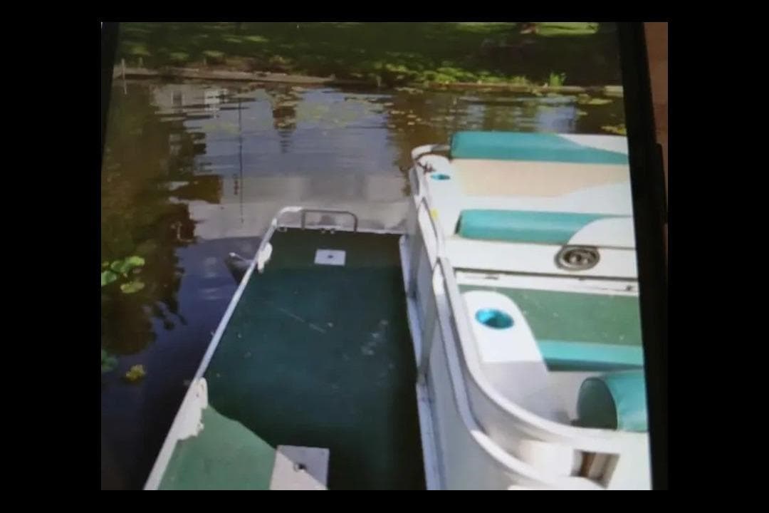 1997 Godfrey SWEETWATER 2424 RE pontoon boat on a calm lake.