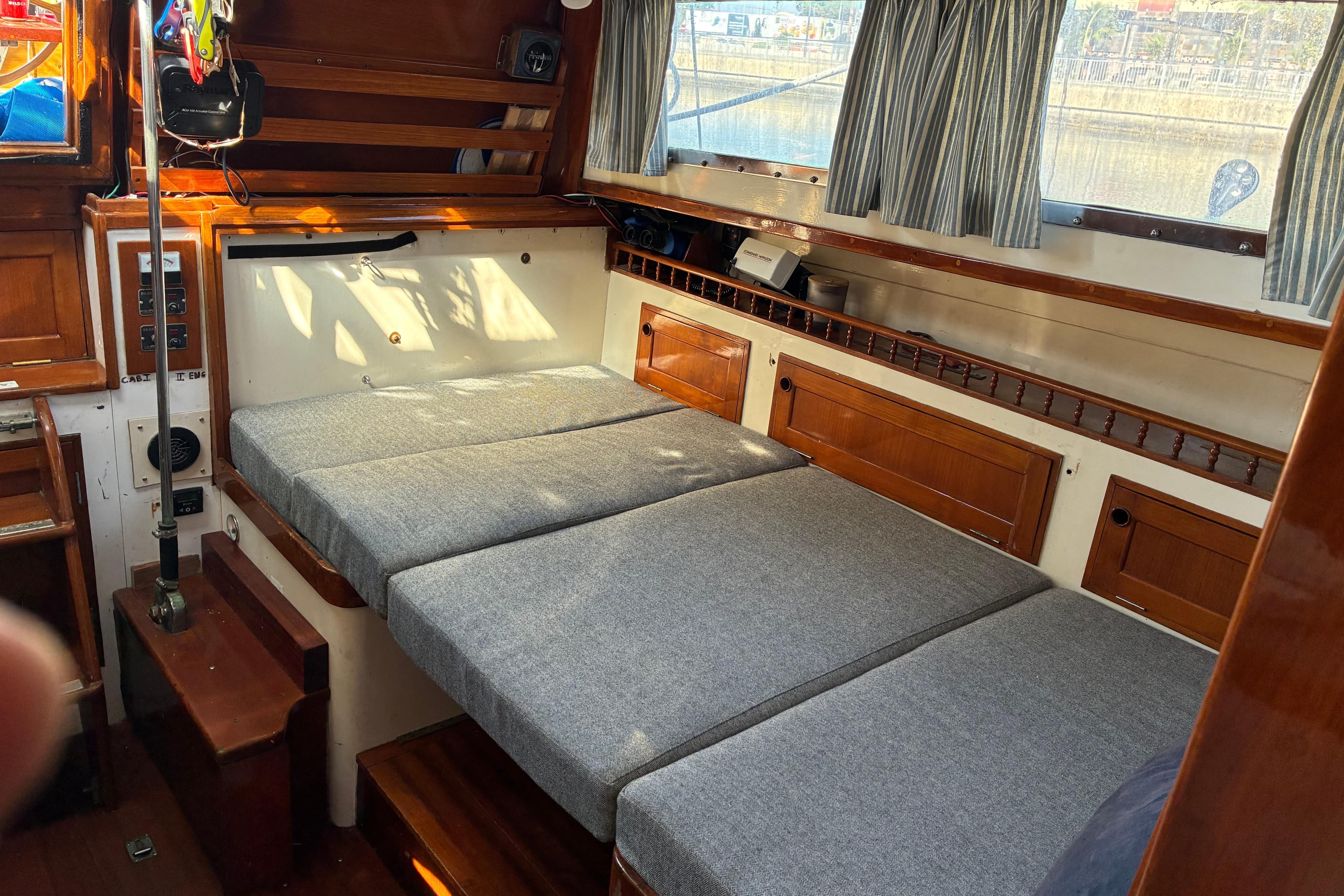 1974 Cheoy Lee Luders Offshore 28 interior with convertible seating and wooden cabinetry.