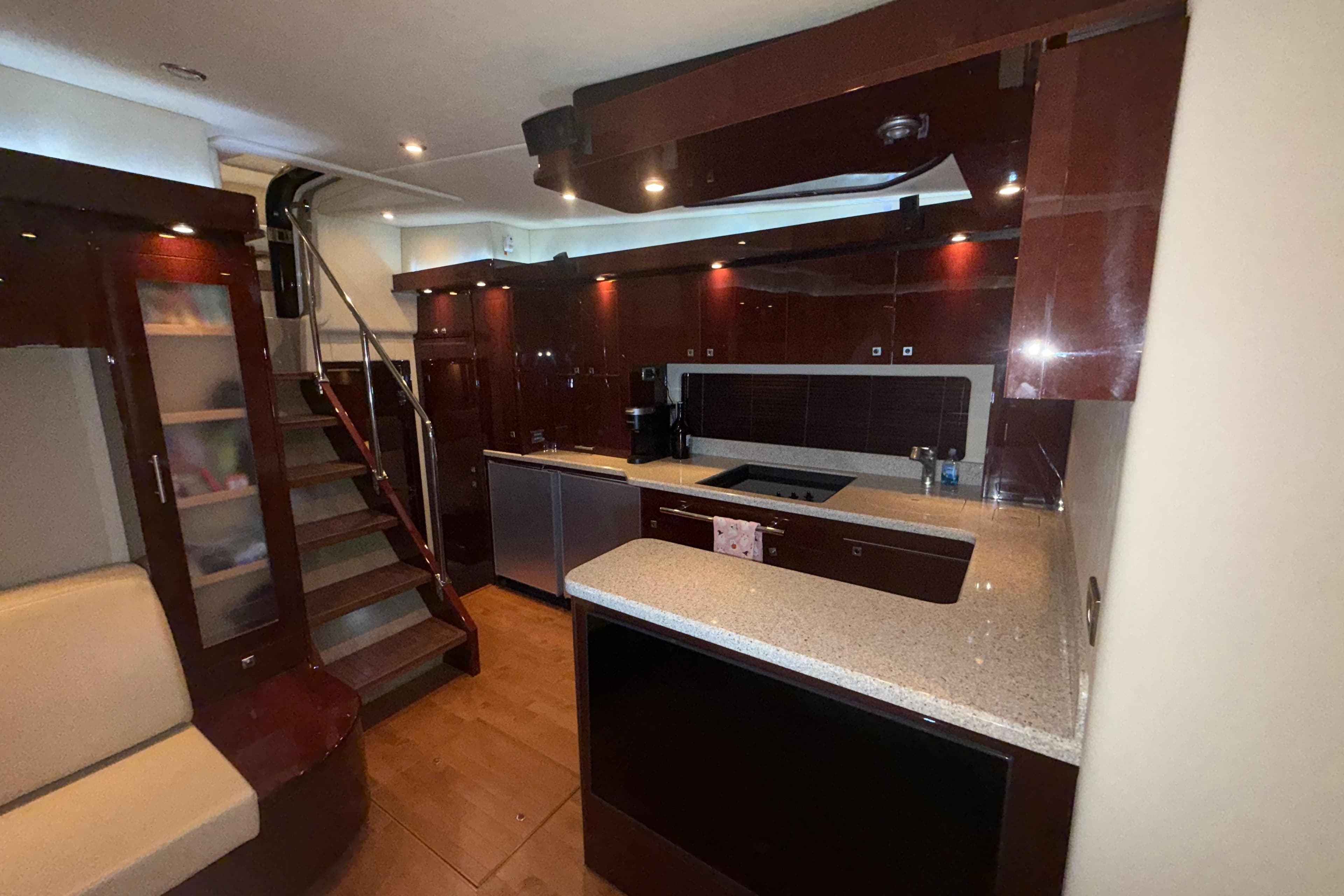Luxurious interior of 2008 Sea Ray 55 Sundancer yacht with modern kitchen and staircase.