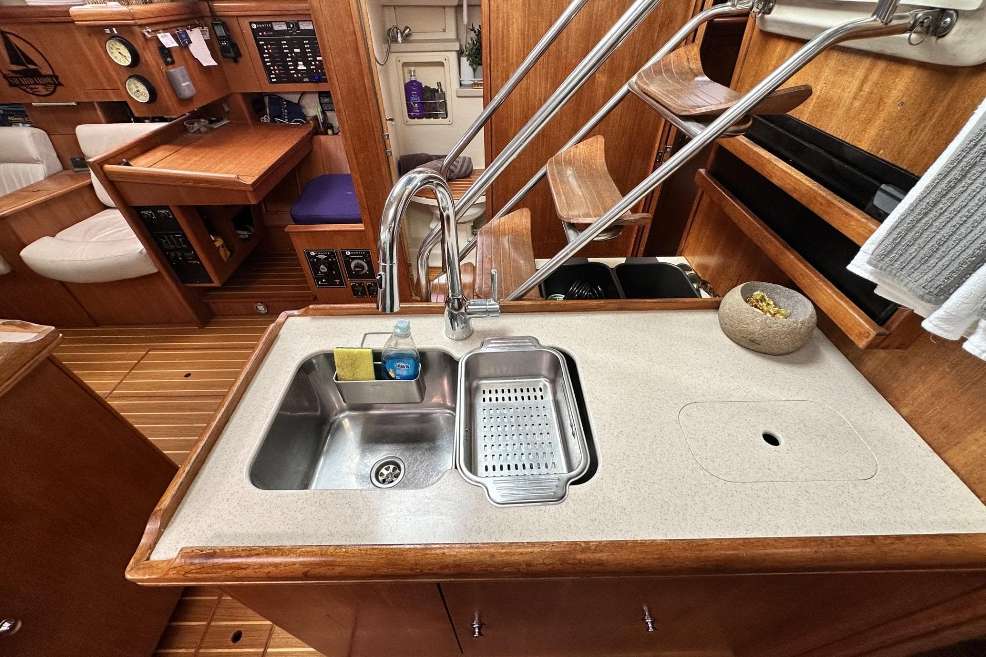 2002 Hunter 466 yacht interior with kitchen sink, wooden cabinetry, and navigation station.