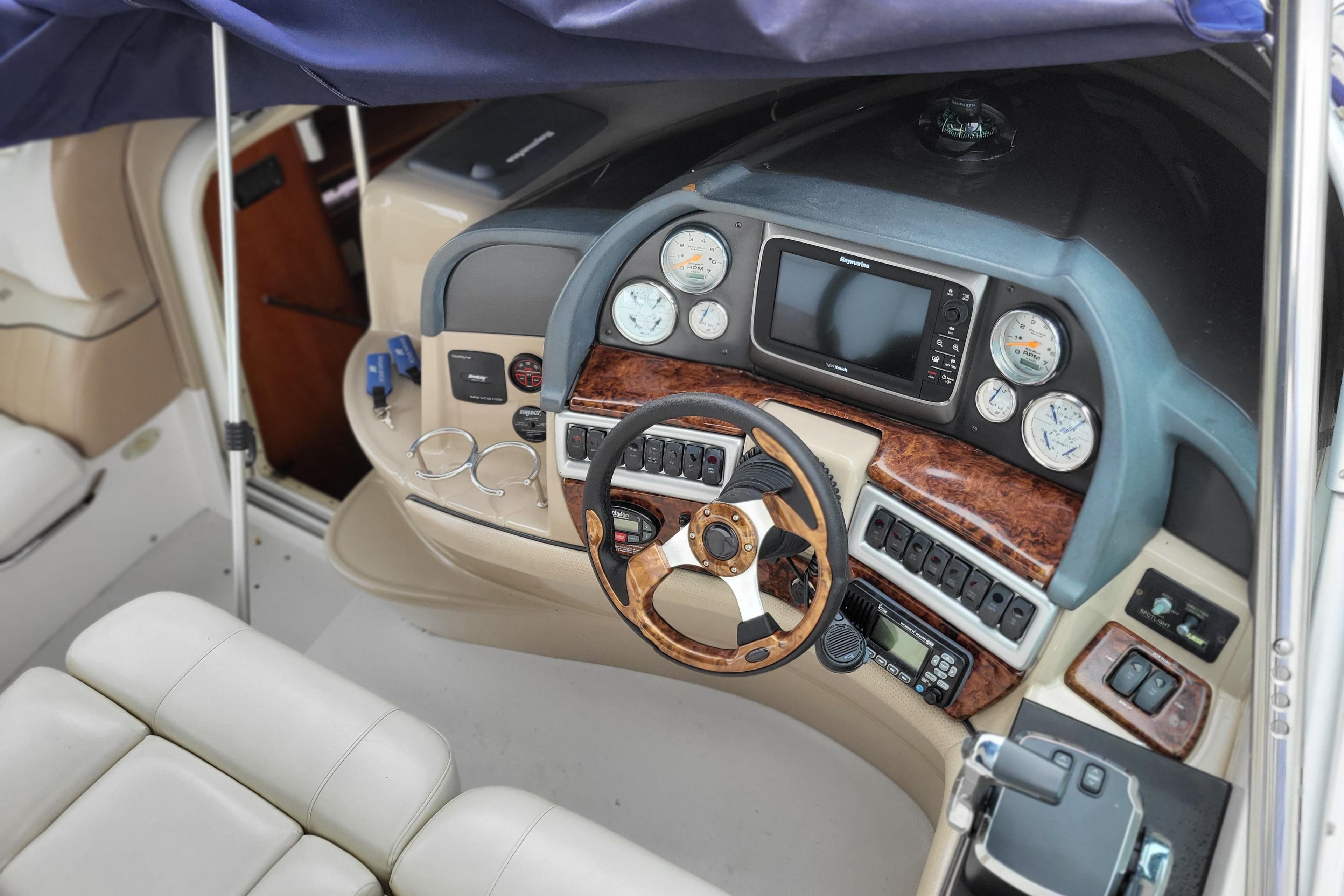 2006 Four Winns 348 Vista boat cockpit with steering wheel and navigation instruments.