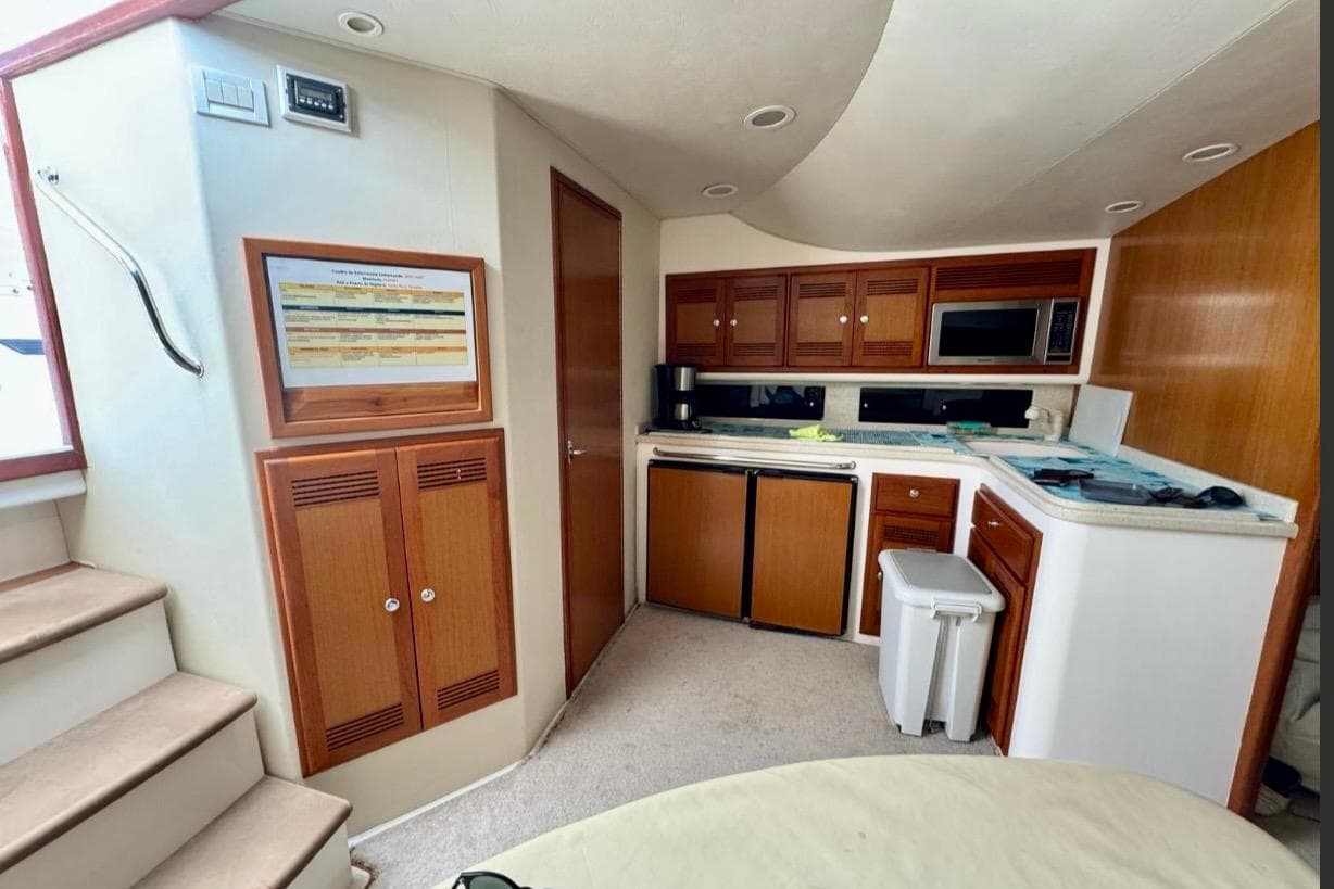 Interior of 2004 Cabo 40 Express Los Suenos yacht with kitchen and wooden cabinetry.