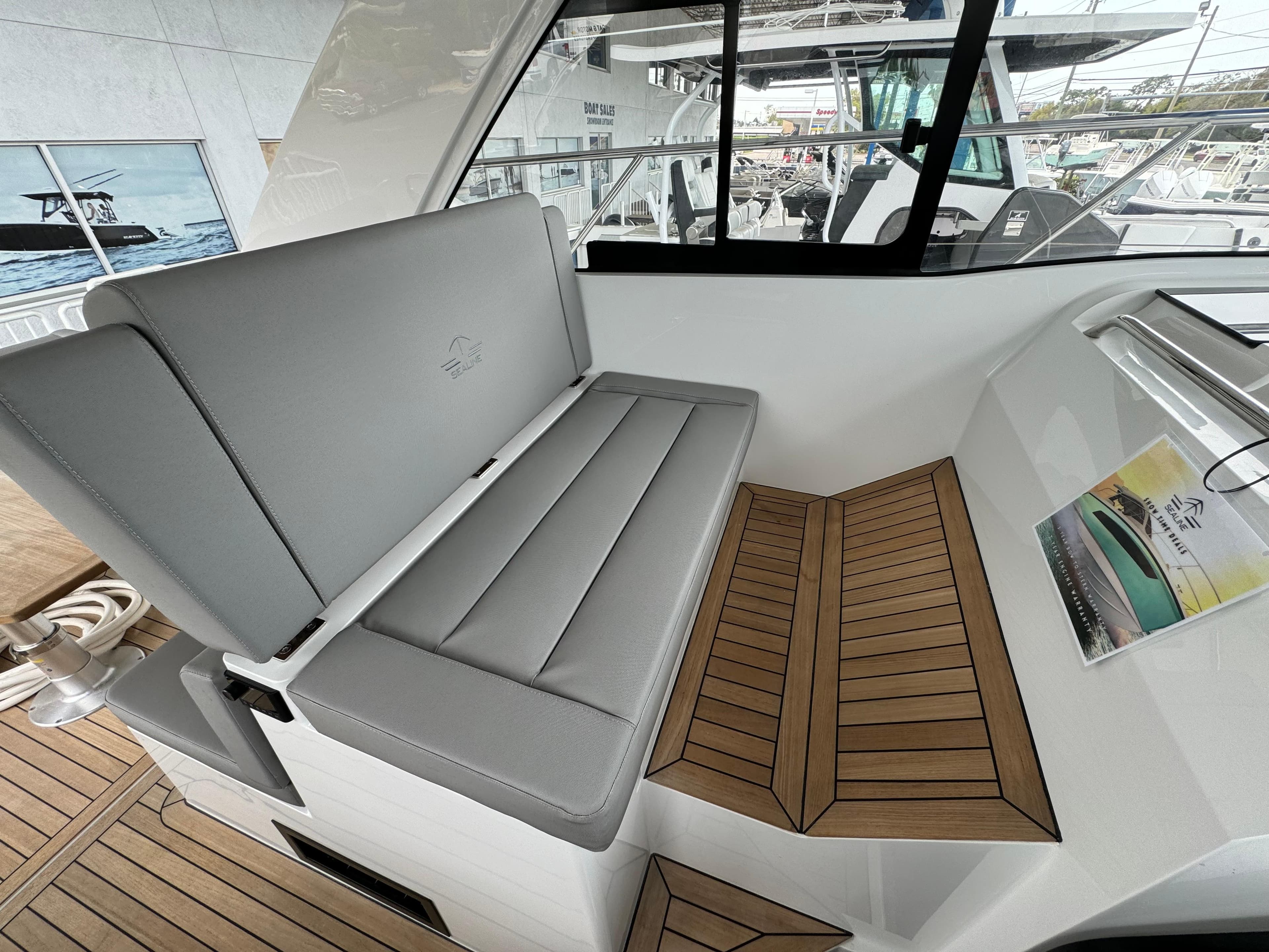 2024 Sealine S335V boat interior with gray seating and wooden flooring.