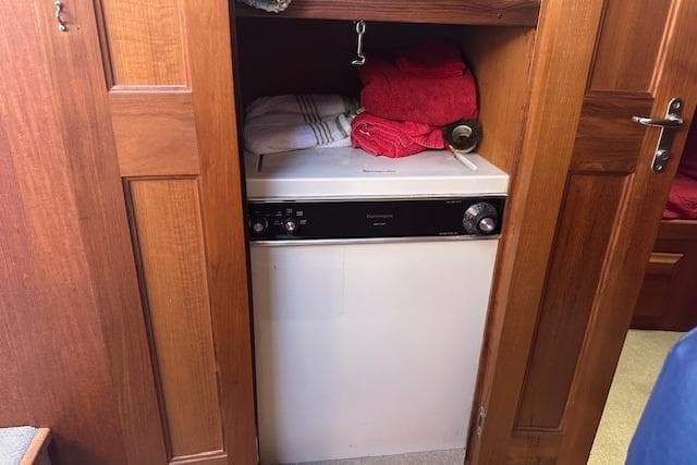 Laundry area inside 1988 Viking 45 Convertible boat with wooden cabinetry and towels.