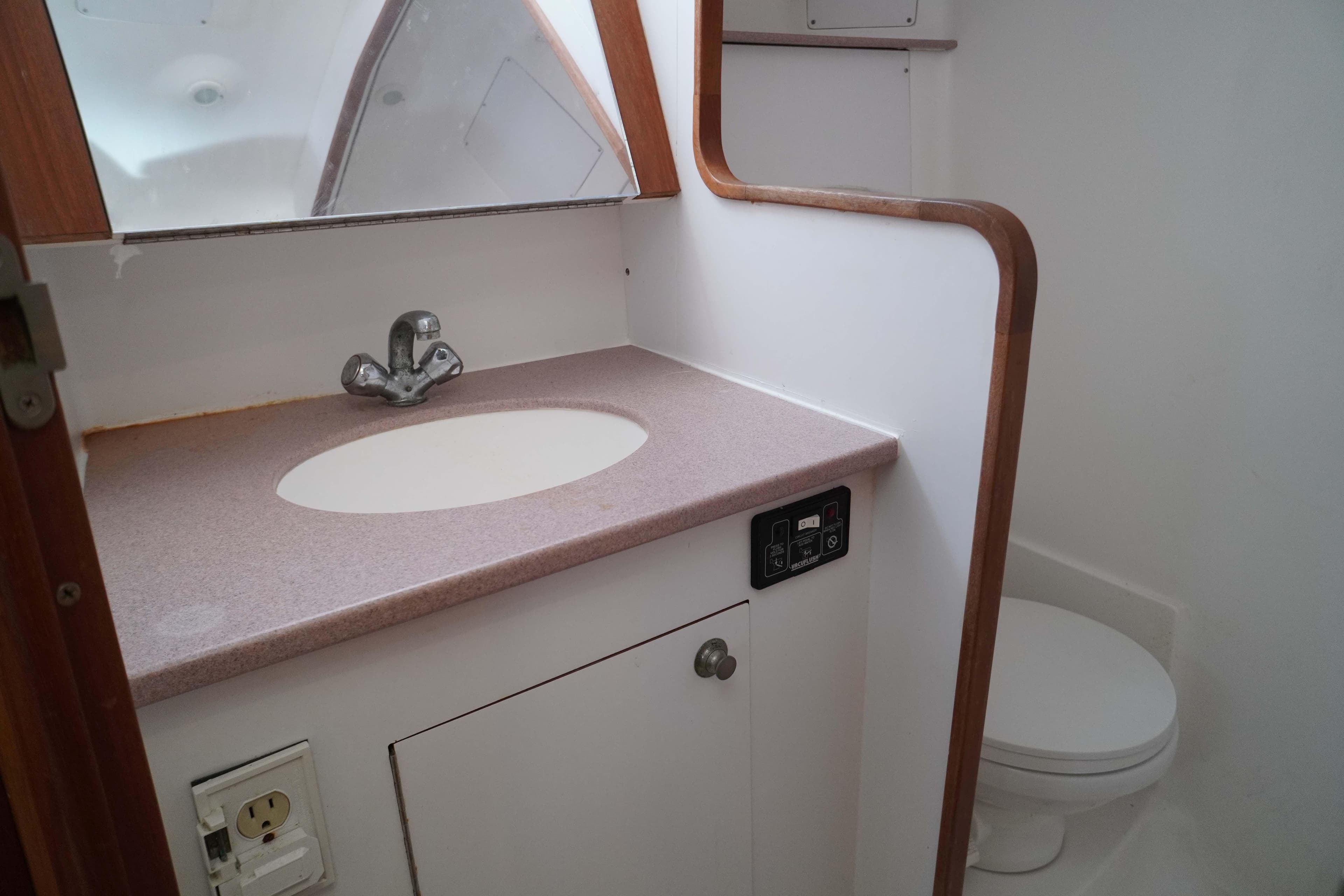 Bathroom interior of 2000 Hunter Passage 420 sailboat, featuring sink and toilet.