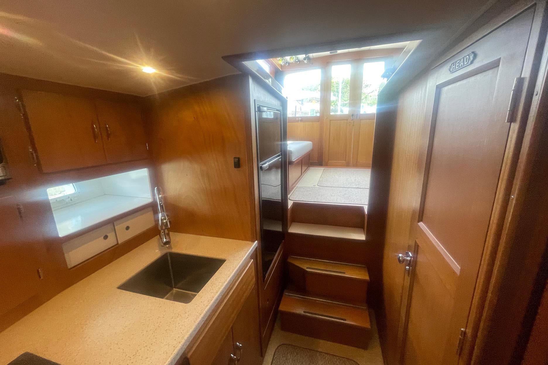 Interior of 1968 Hatteras 34 Sport Fisherman with wooden cabinetry and stairs.