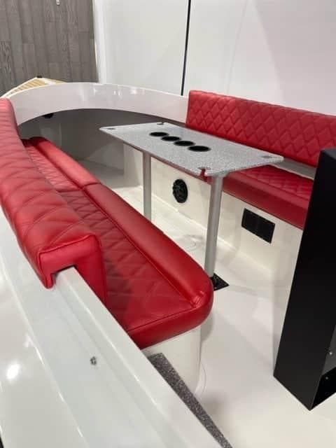 2024 Vision Marine Technologies Fantail 217 interior with red seating and a central table.