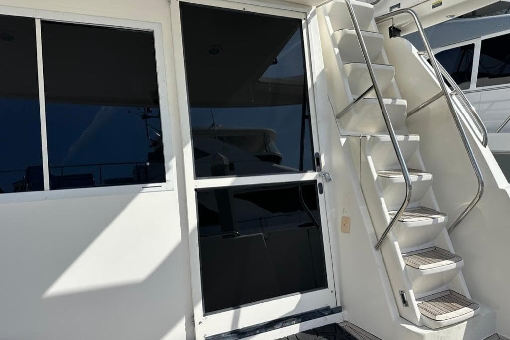 1999 Bayliner 5788 Pilot House Motoryacht with exterior stairs and windows.