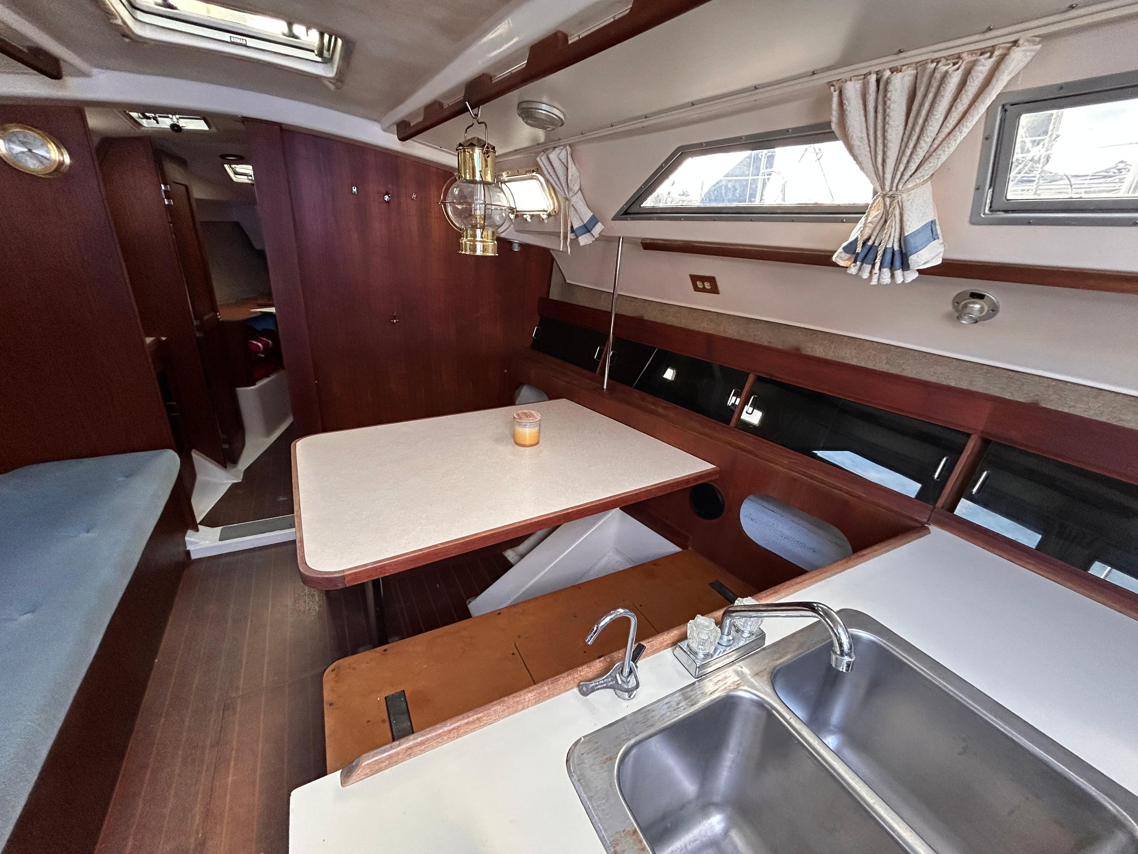 Interior of 1983 Hunter 34 sailboat with dining area and kitchen sink.