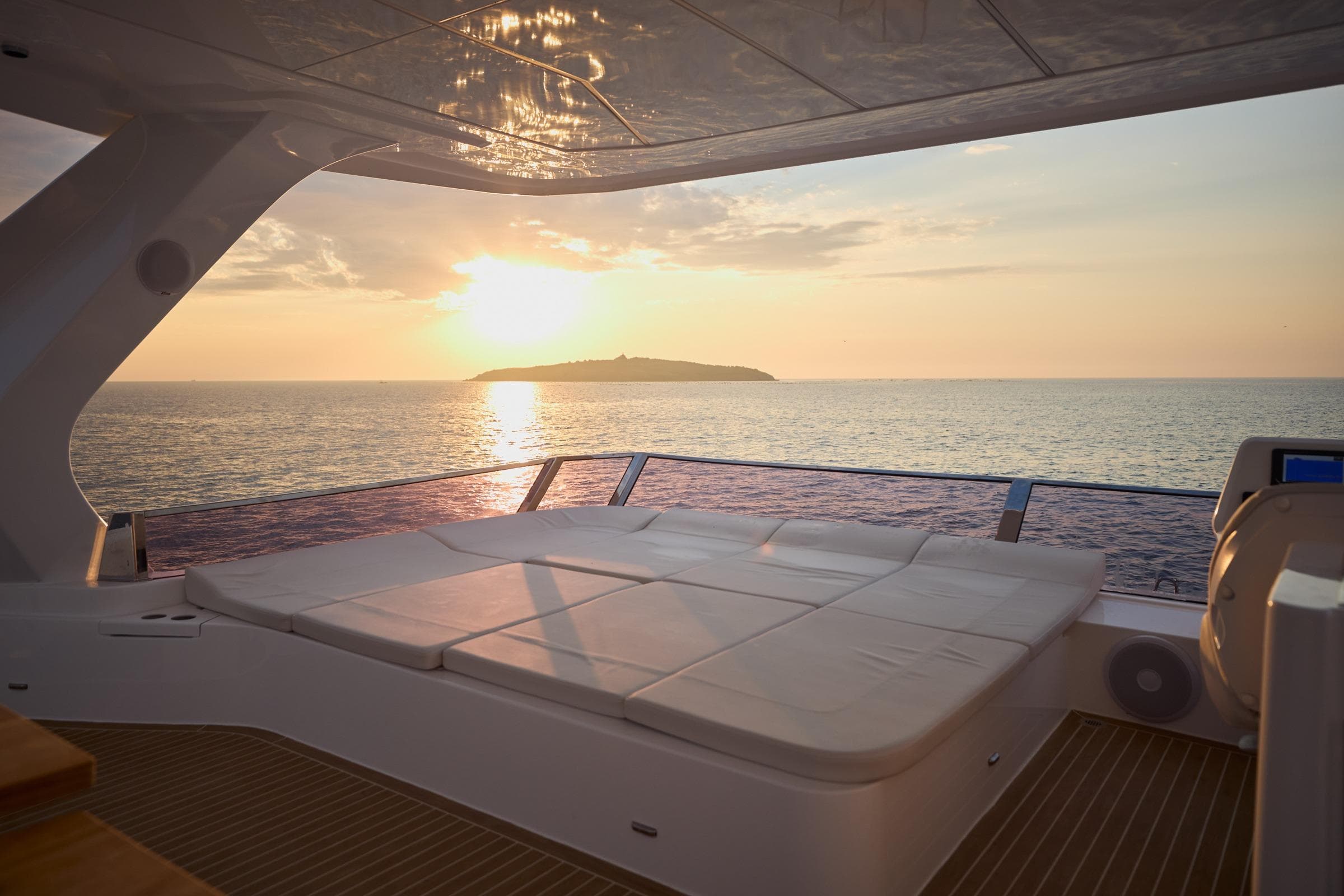 Luxurious Omaya 50 Power Catamaran at sunset, 2025 model, with ocean view and island backdrop.