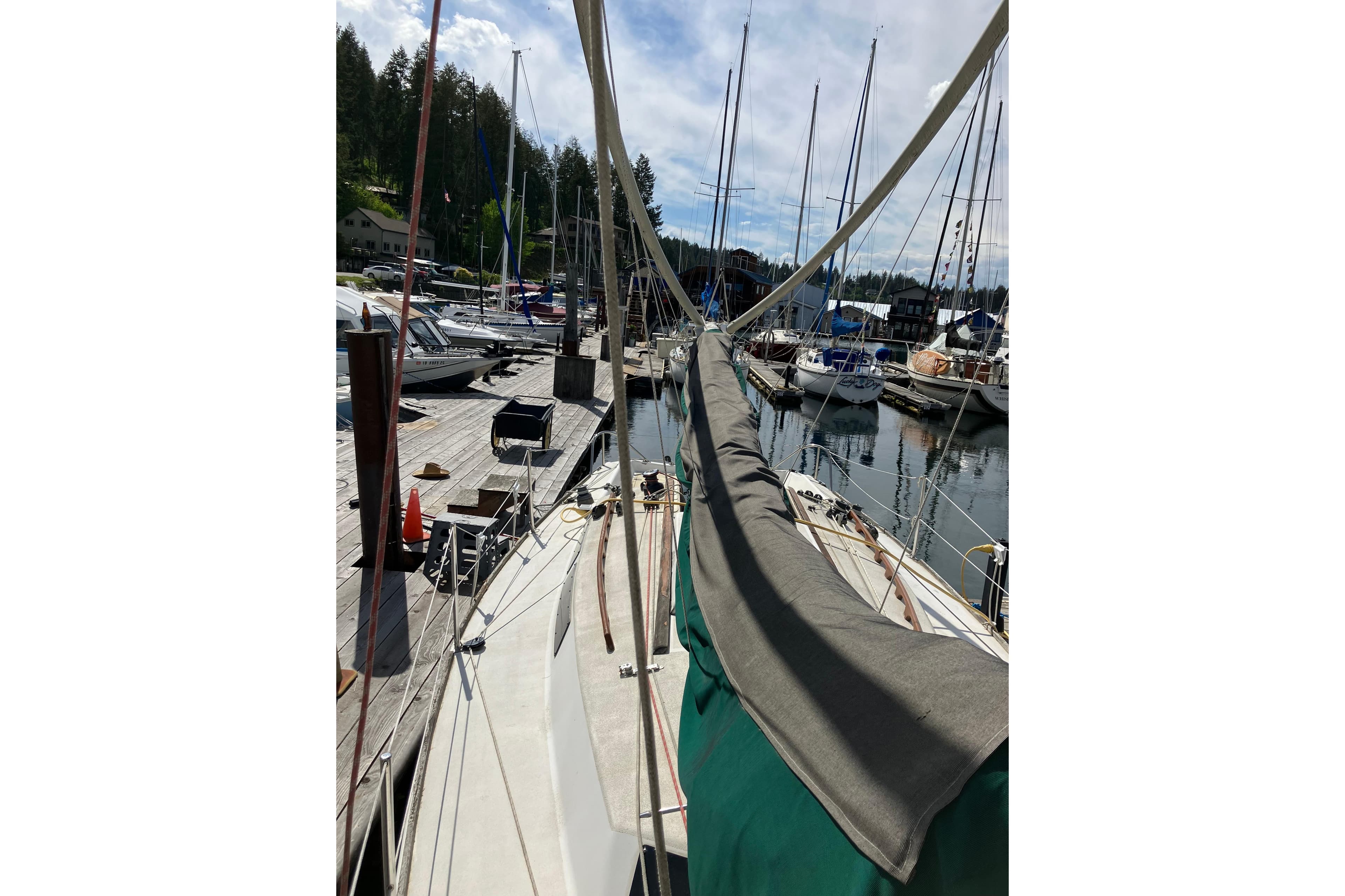 Sailboat docked at marina, Wylie 30 model, 1996, surrounded by other boats.