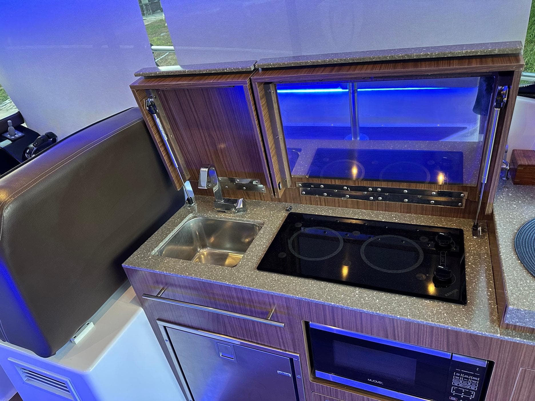 2020 Four Winns Vista 355 Coupe kitchen with sink, stove, and microwave.