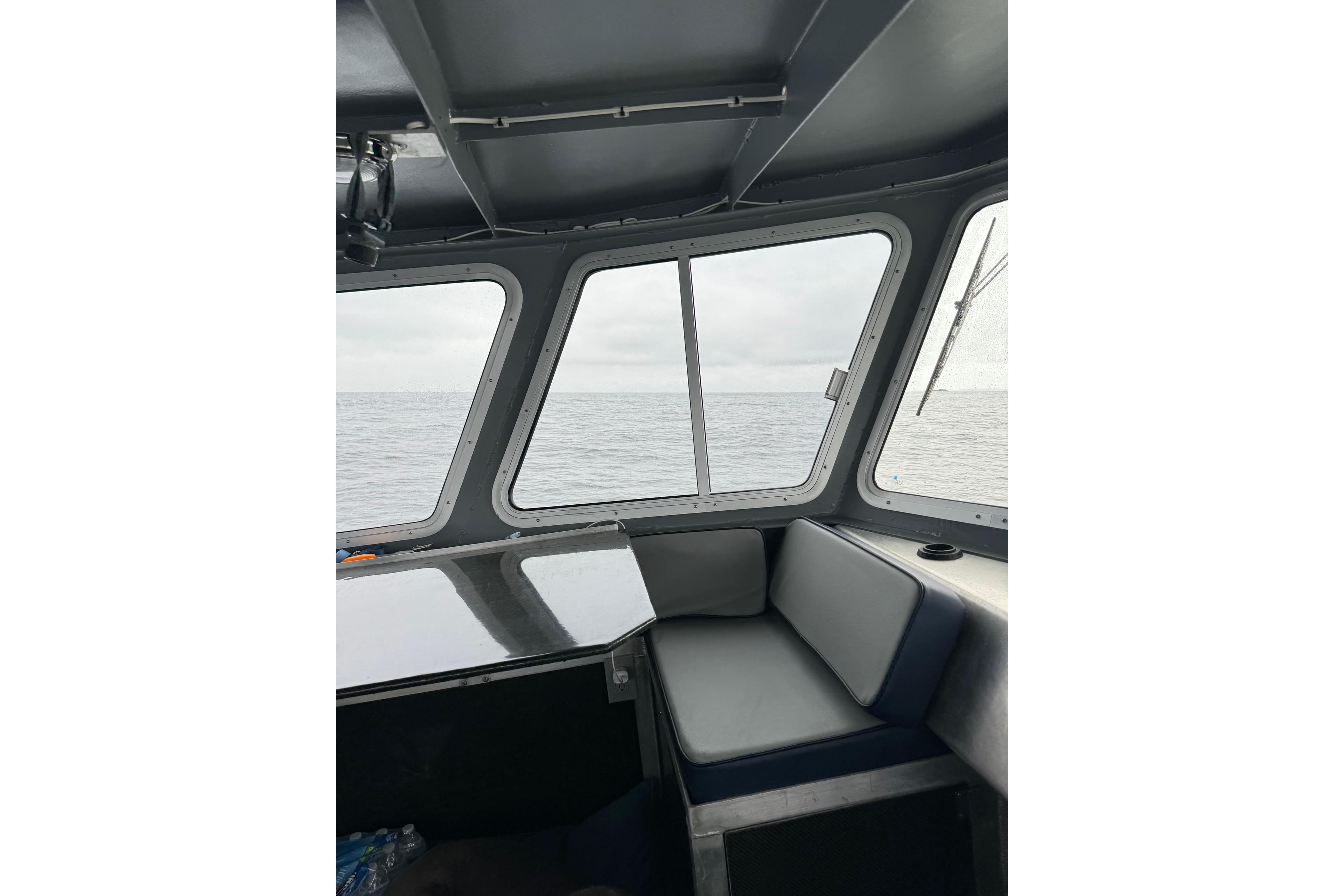 Interior view of 2021 Custom Aluminum Crabber boat with ocean through windows.