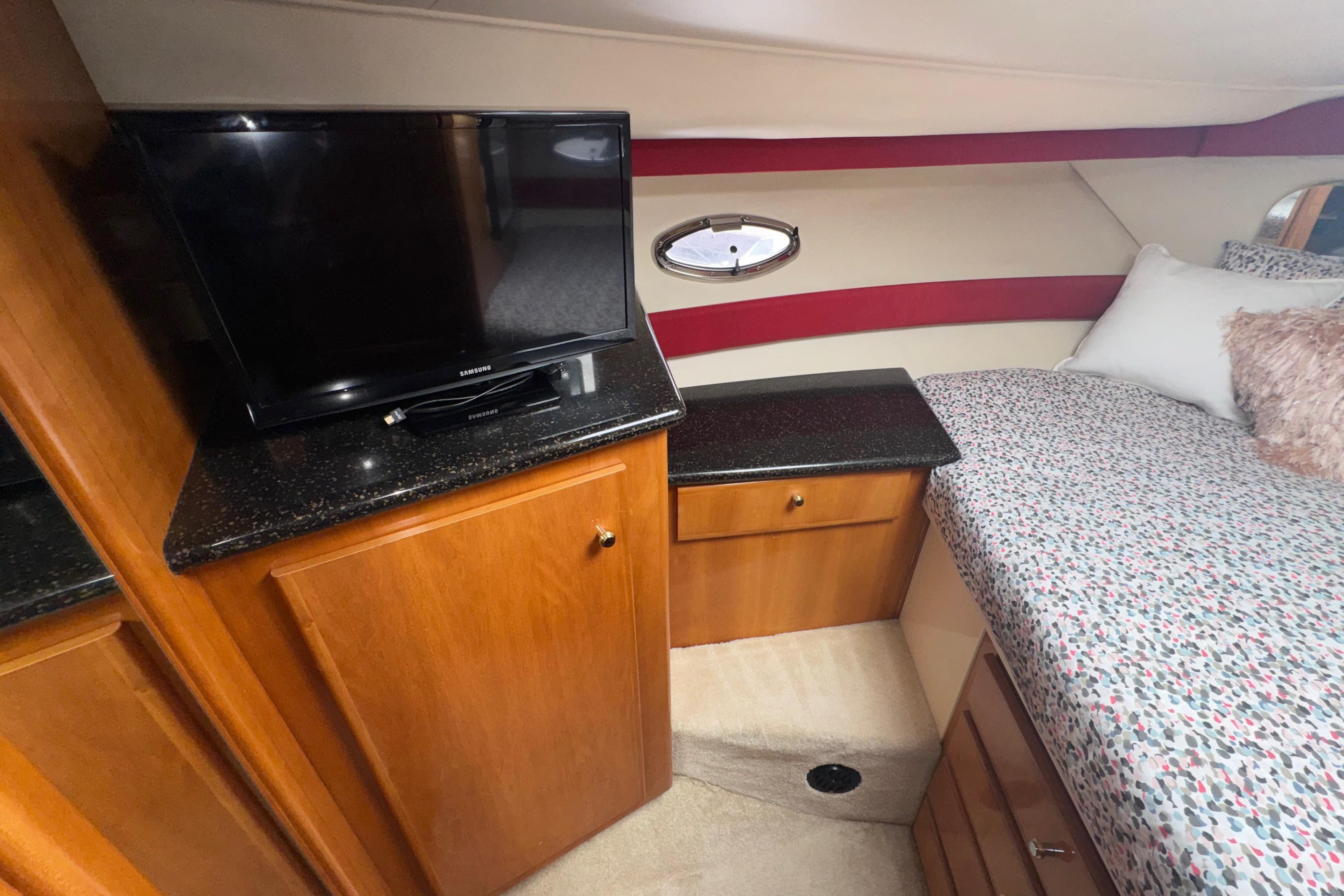 Interior of 2001 Carver 356 Motor Yacht with TV, cabinets, and bed.