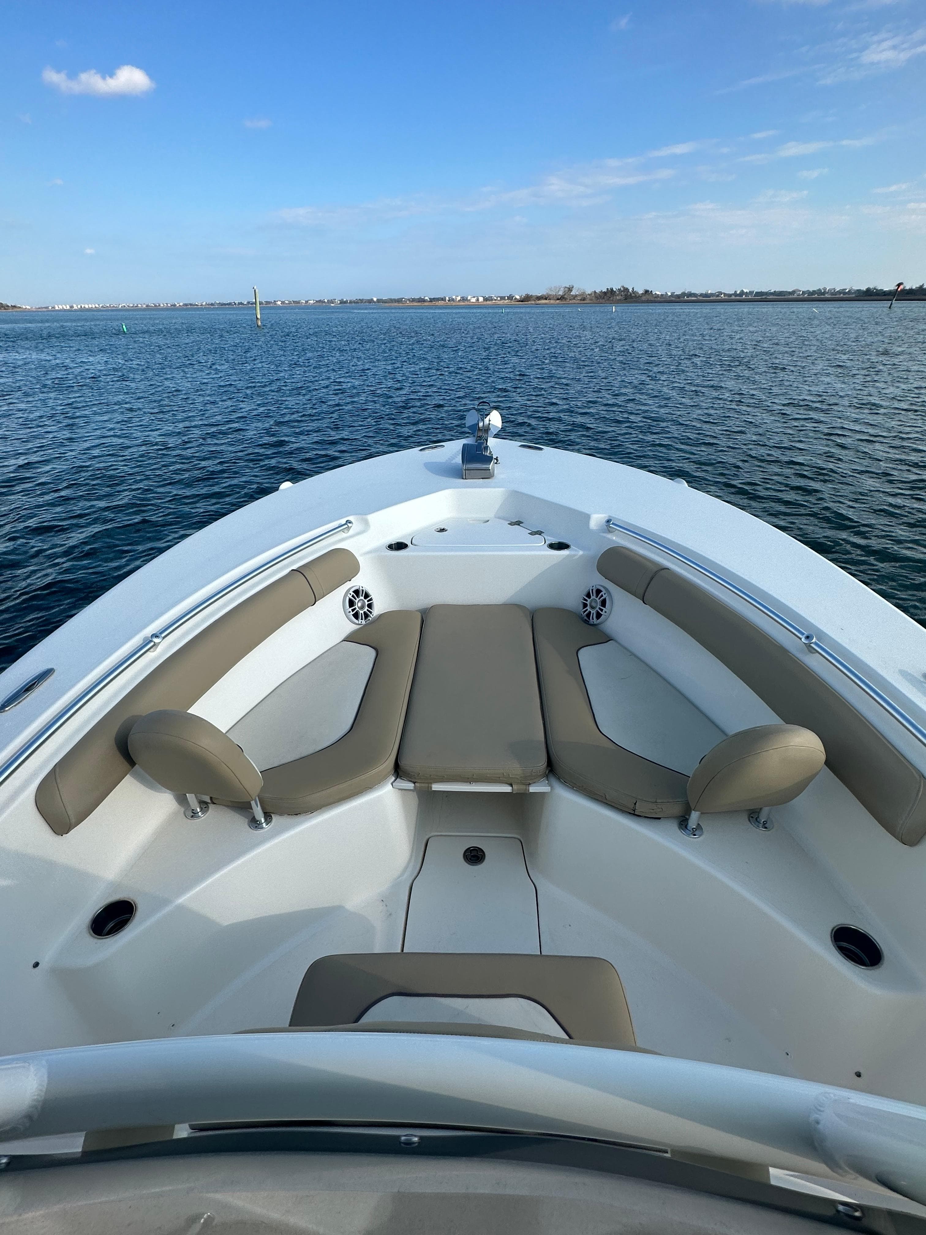 2018 Key West 244 CC boat on calm water, featuring spacious seating and clear blue skies.