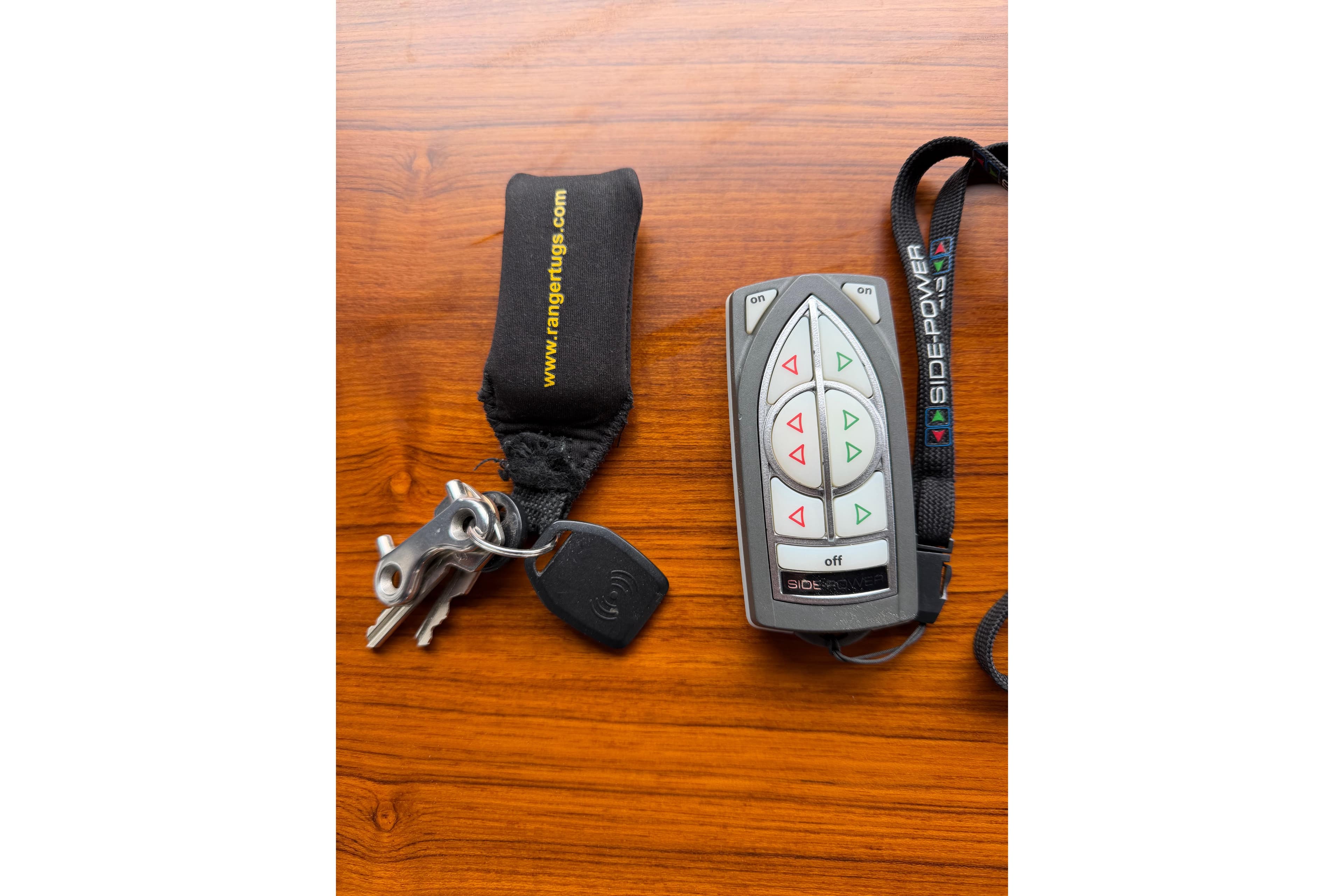 Remote control and keys for 2014 Ranger Tugs R-25 SC on wooden surface.