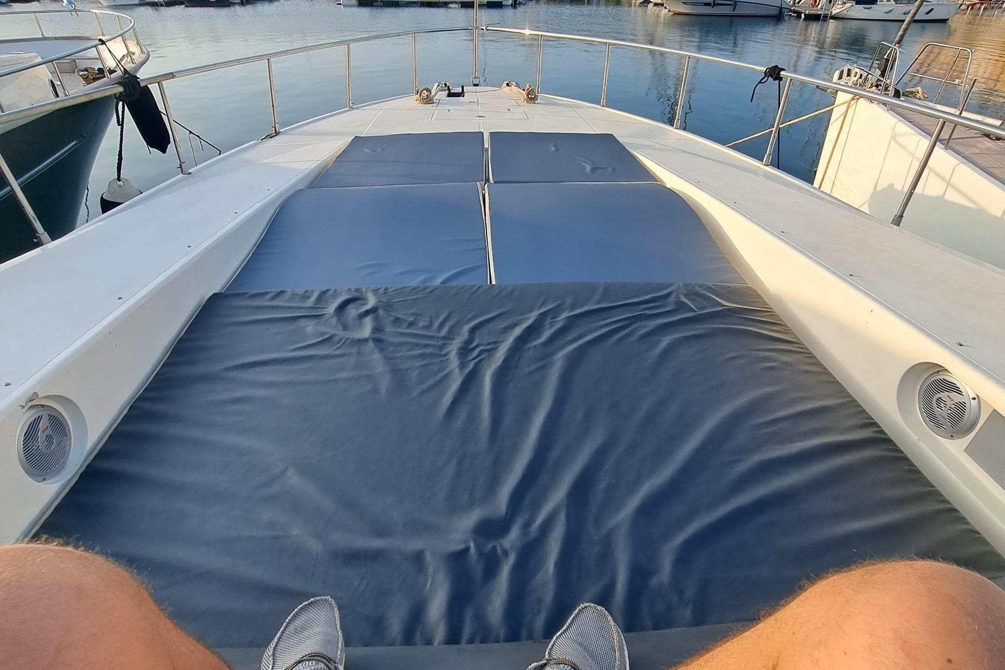 Deck view of 1999 Arno Leopard 23 yacht with sunbathing area and marina backdrop.