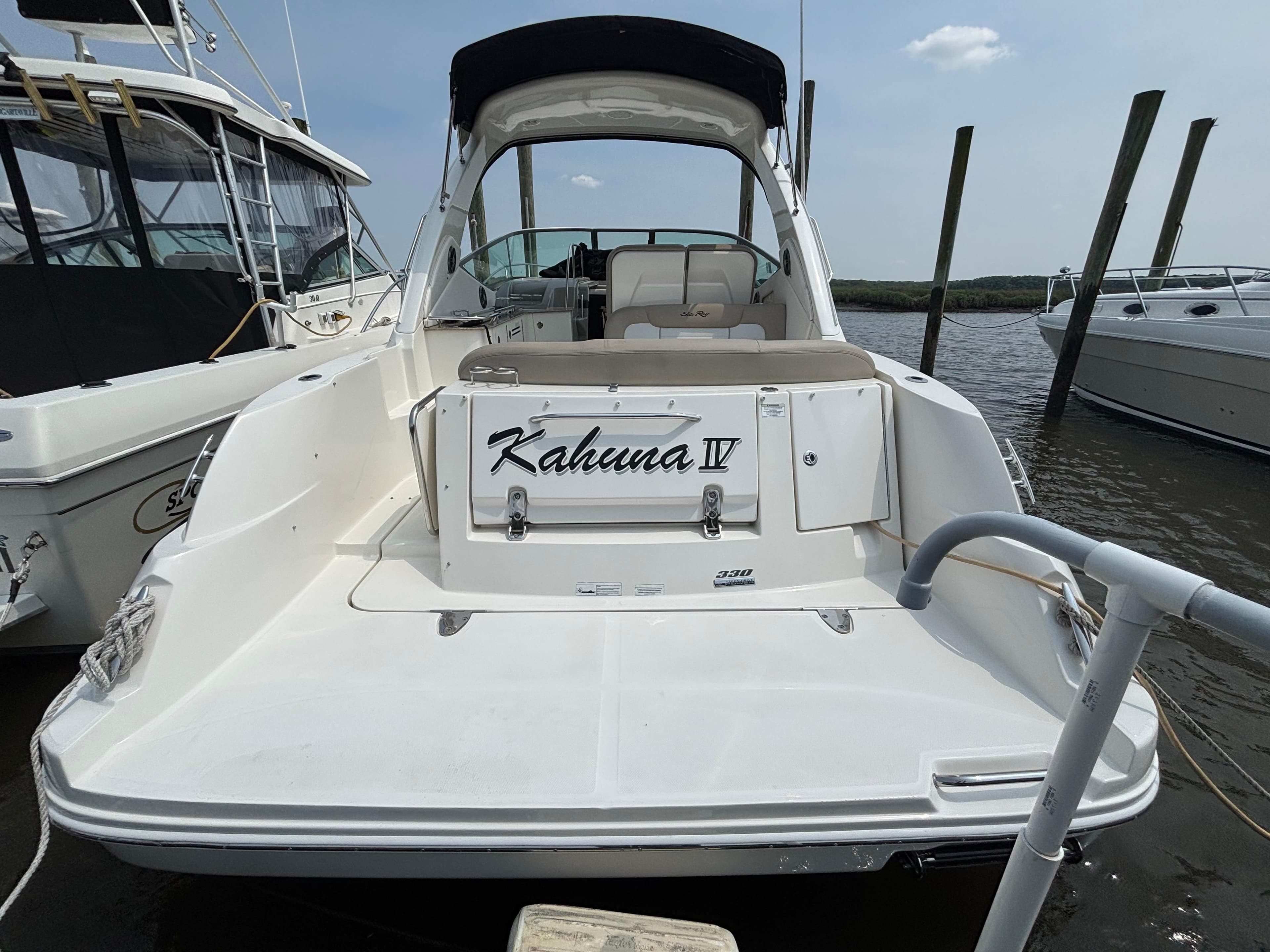 2014 Sea Ray 330 Sundancer boat docked, rear view with "Kahuna IV" nameplate.