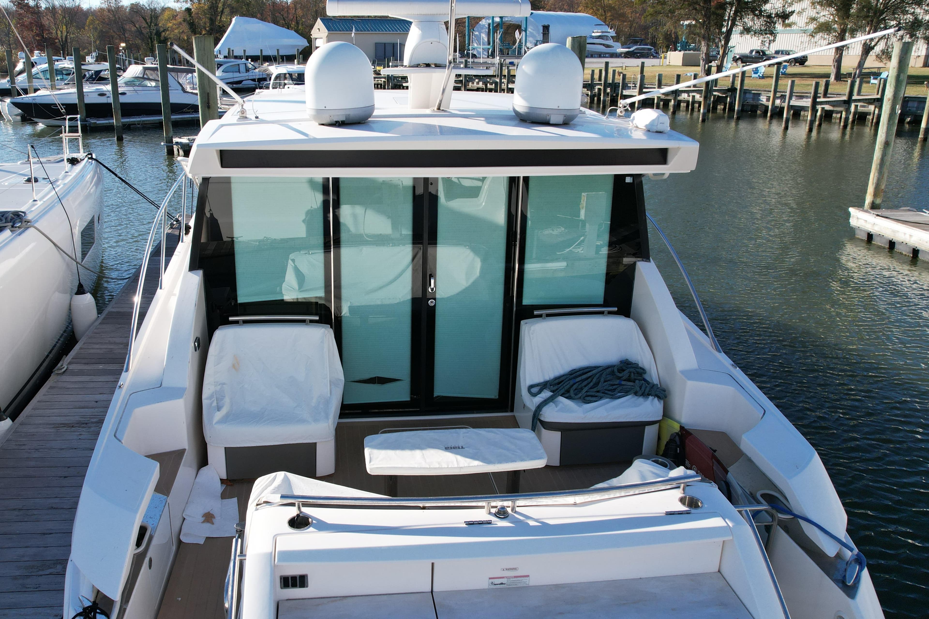 2017 Tiara 44 Coupe yacht docked at marina, featuring spacious deck and modern design.