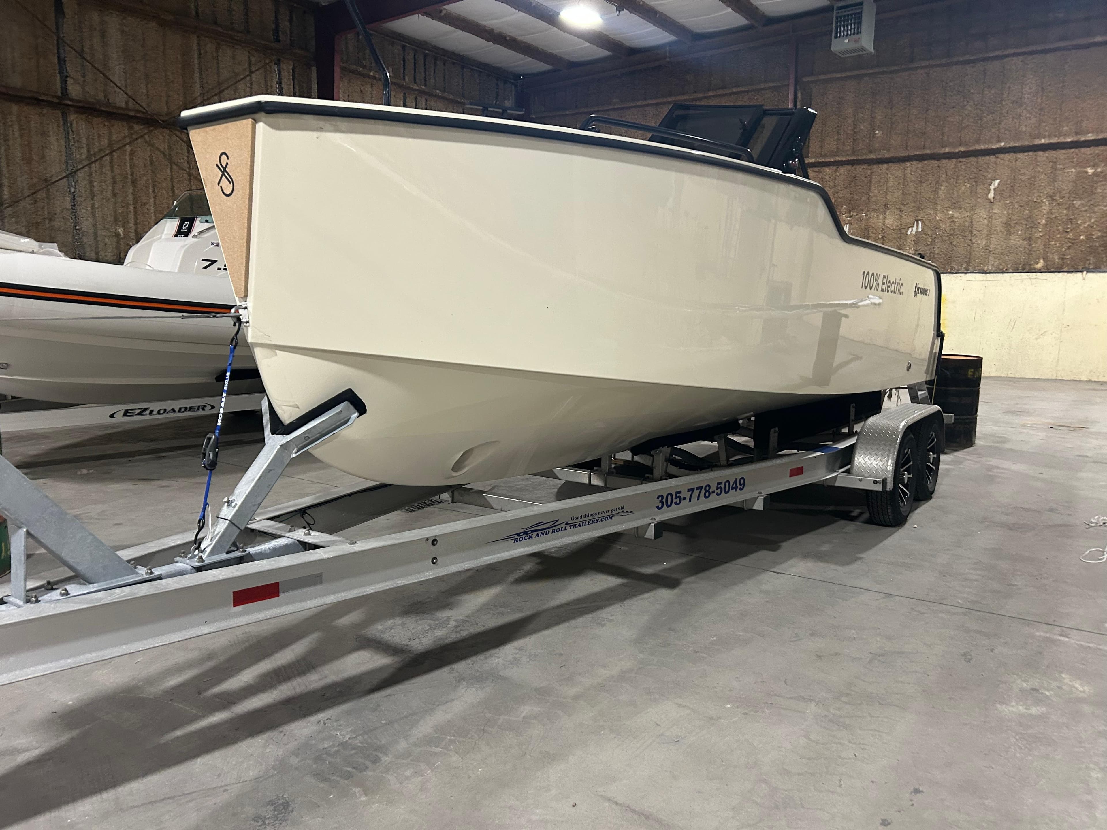 2024 X Shore 1 electric boat on trailer in indoor storage facility.