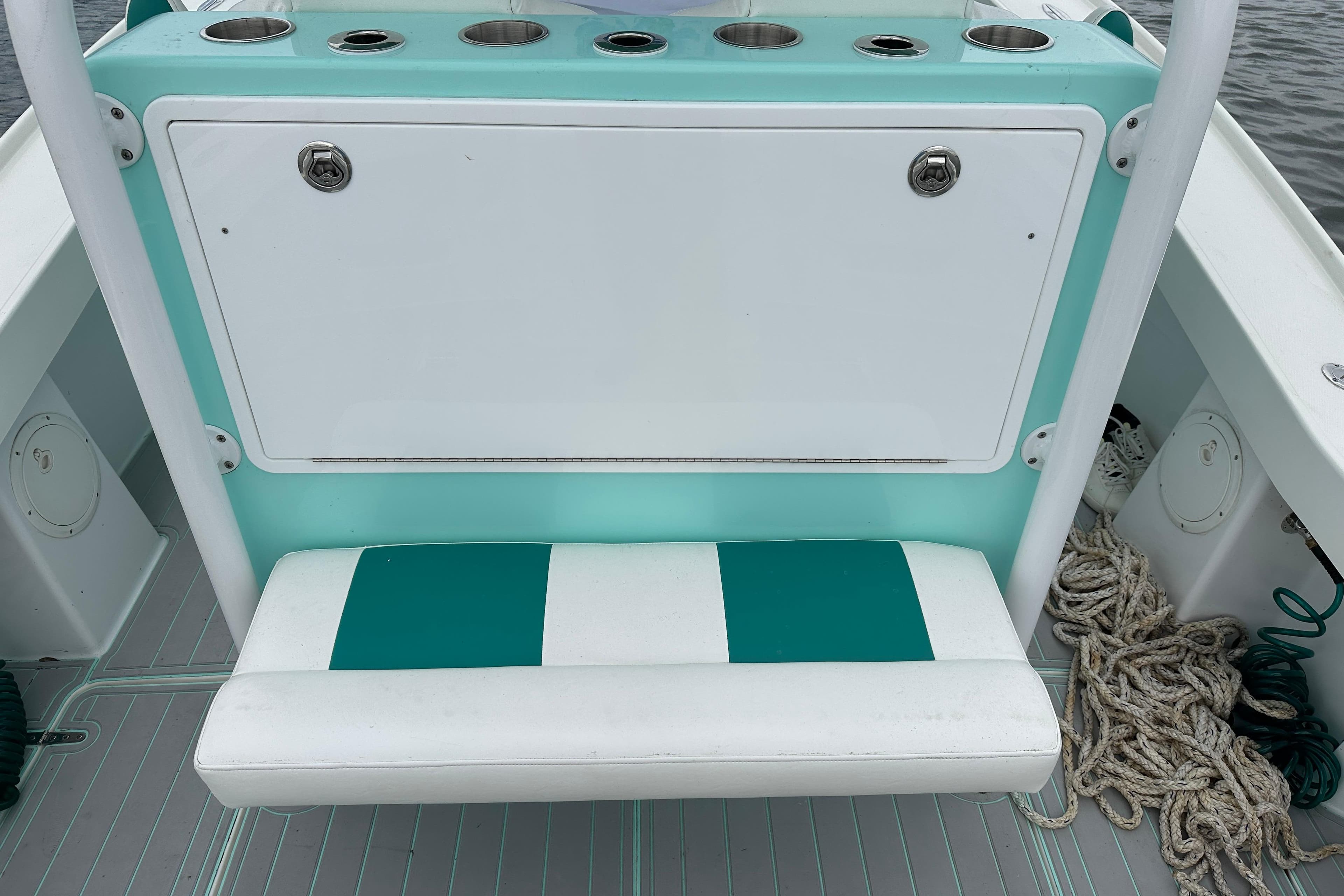 Stanley White Fishmaster 2026 boat seat with teal and white design, featuring storage and cup holders.