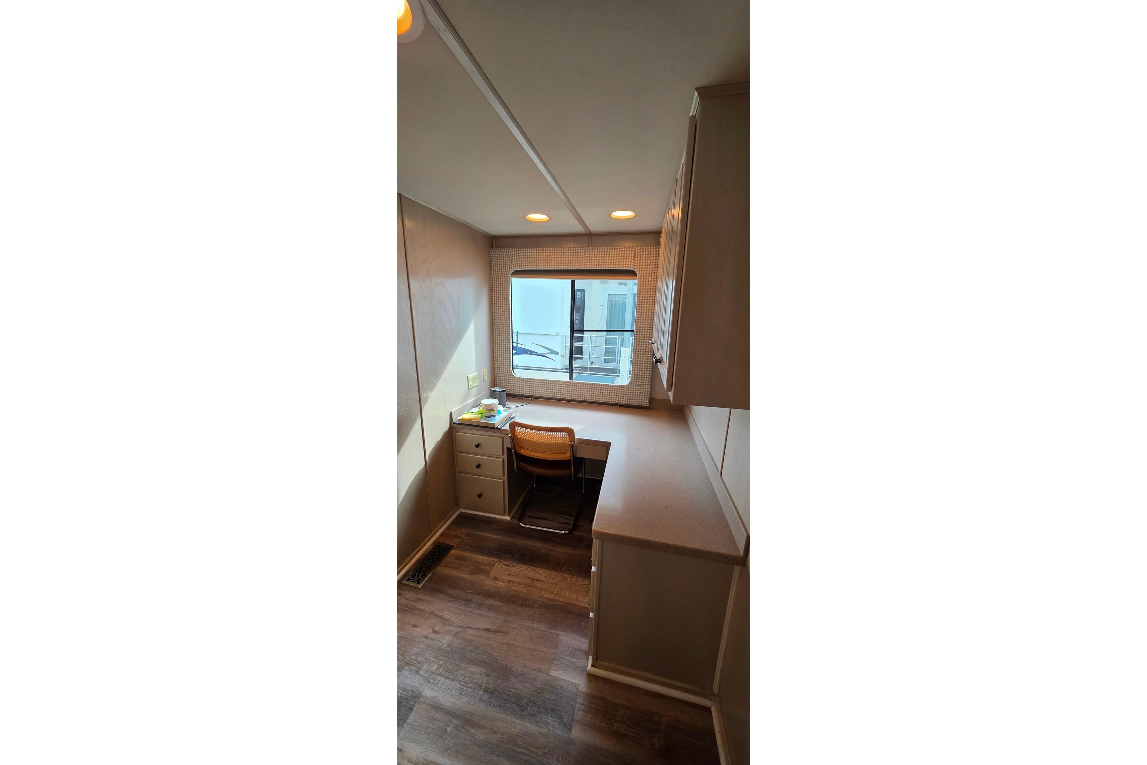 Interior of 1999 Stardust Cruisers 16x60 houseboat with desk and window view.