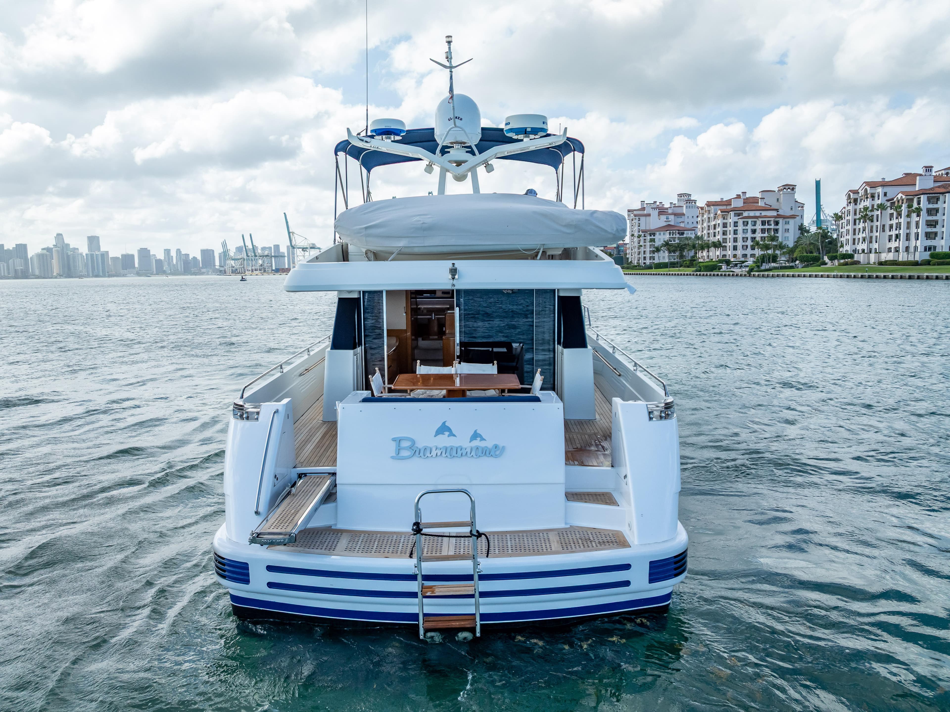 Sanlorenzo 62 yacht from 1995 on water, city skyline in background.
