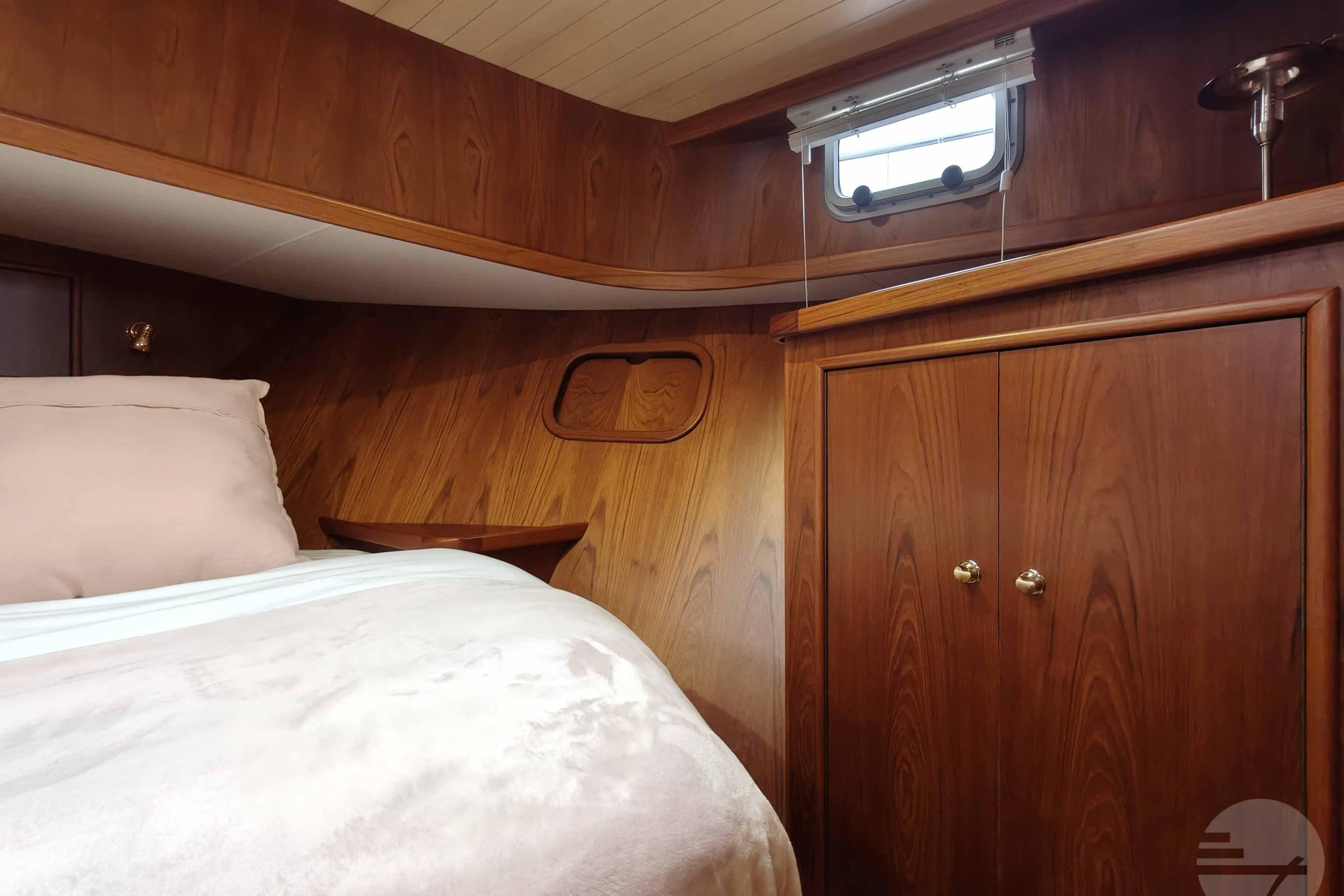 Cozy cabin interior of 2001 Pikmeerkruiser 11.50 OK Royal with wood paneling and bedding.