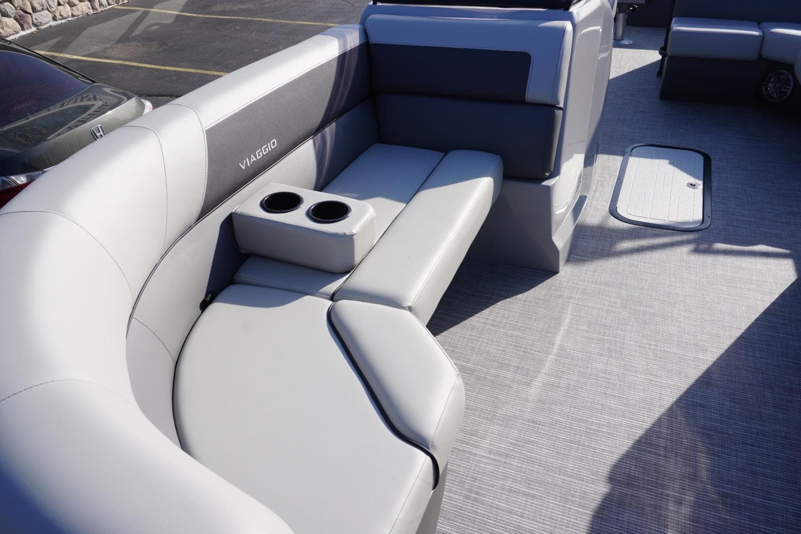 Luxurious seating on 2026 Viaggio Lago V-R boat with cup holders and modern design.