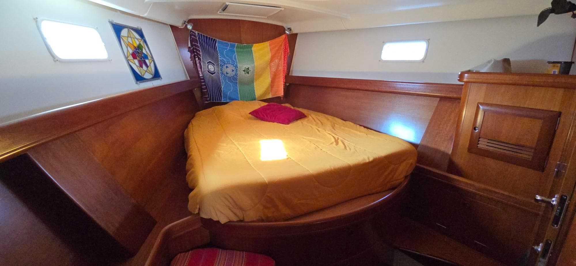 Cozy cabin interior of 2001 Beneteau Oceanis 473 sailboat with colorful decor and wooden finish.